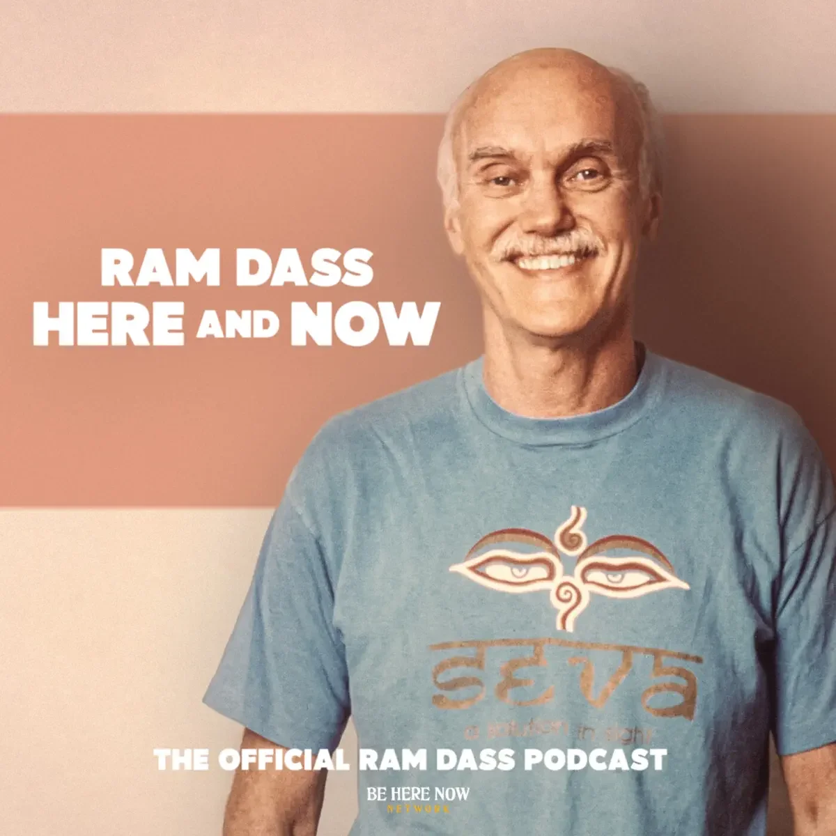 A smiling older man with a mustache standing against a background with a pinkish hue. He is wearing a blue t-shirt with a stylized logo and the text 'seva' on it. The image has text that reads 'Ram Dass Here and Now' and 'The Official Ram Dass Podcast'.