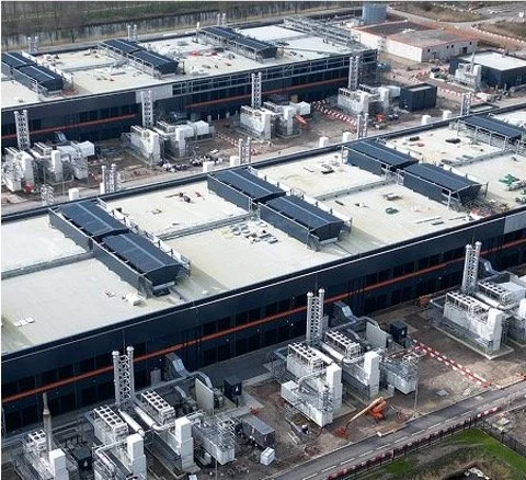 Multiple industrial HVAC units installed on the flat rooftops of large commercial buildings.
