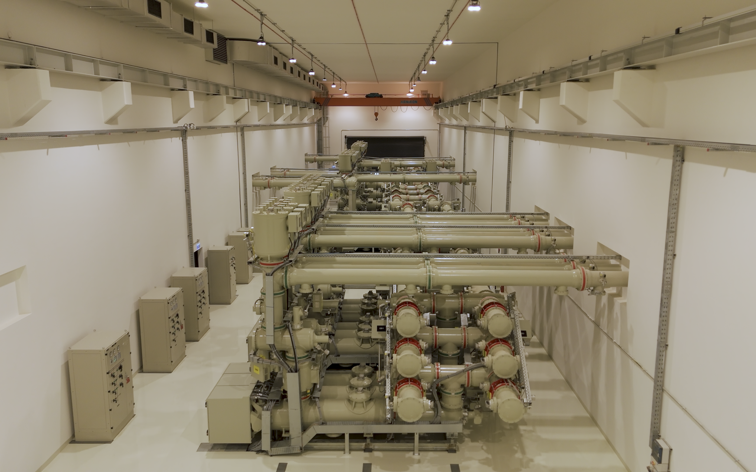 Large industrial machine with multiple pipes and control panels in a clean, well-lit room.