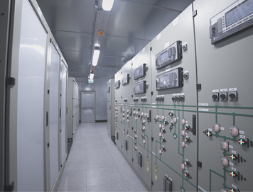Industrial electrical control panels with switches and gauges in a clean, well-lit utility room.
