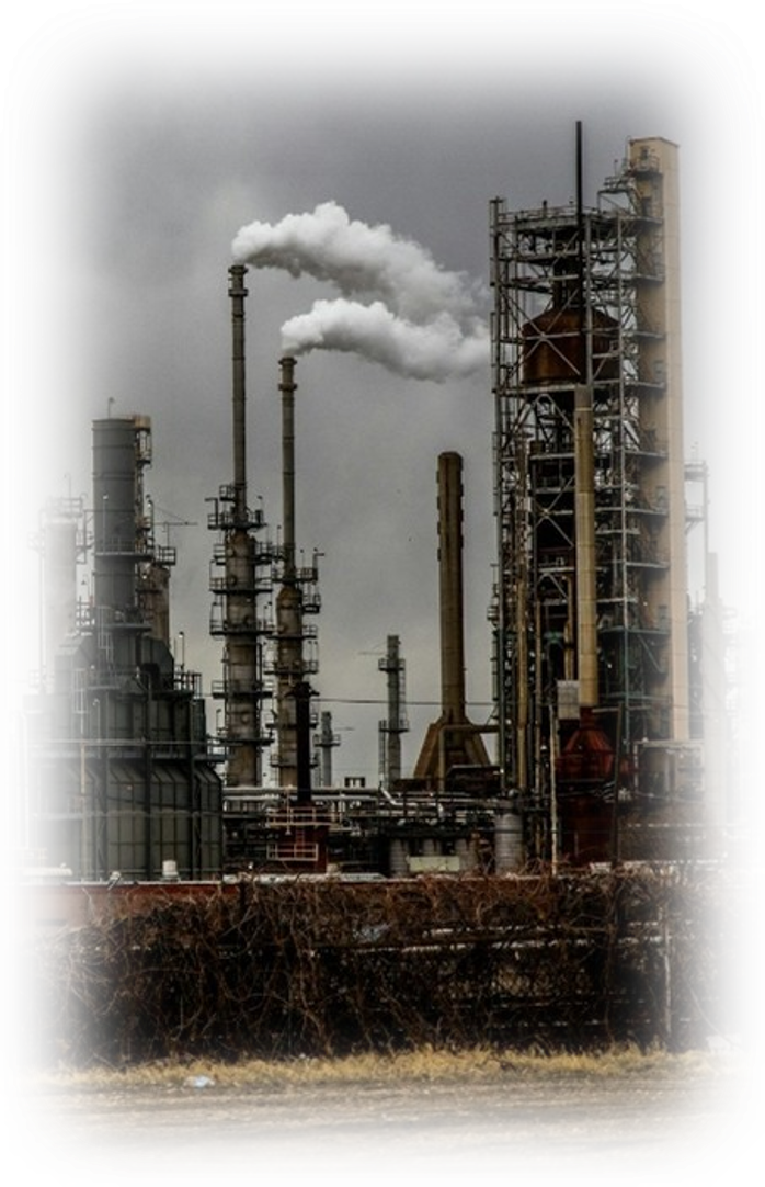Industrial factory with tall smokestacks emitting white smoke, surrounded by metal structures and dark clouds in the sky.