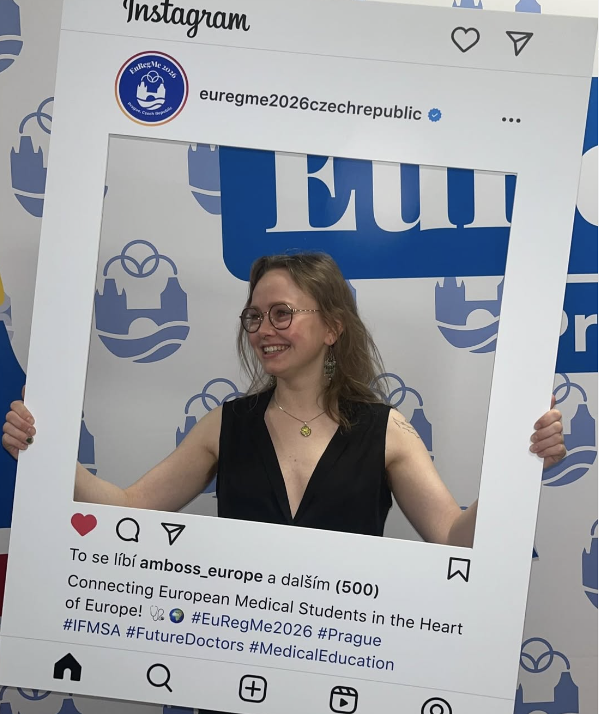 Billede fra international konference. Kvinde med briller smiler og holder en Facebook-ramme, der efterligner en Instagram-post.