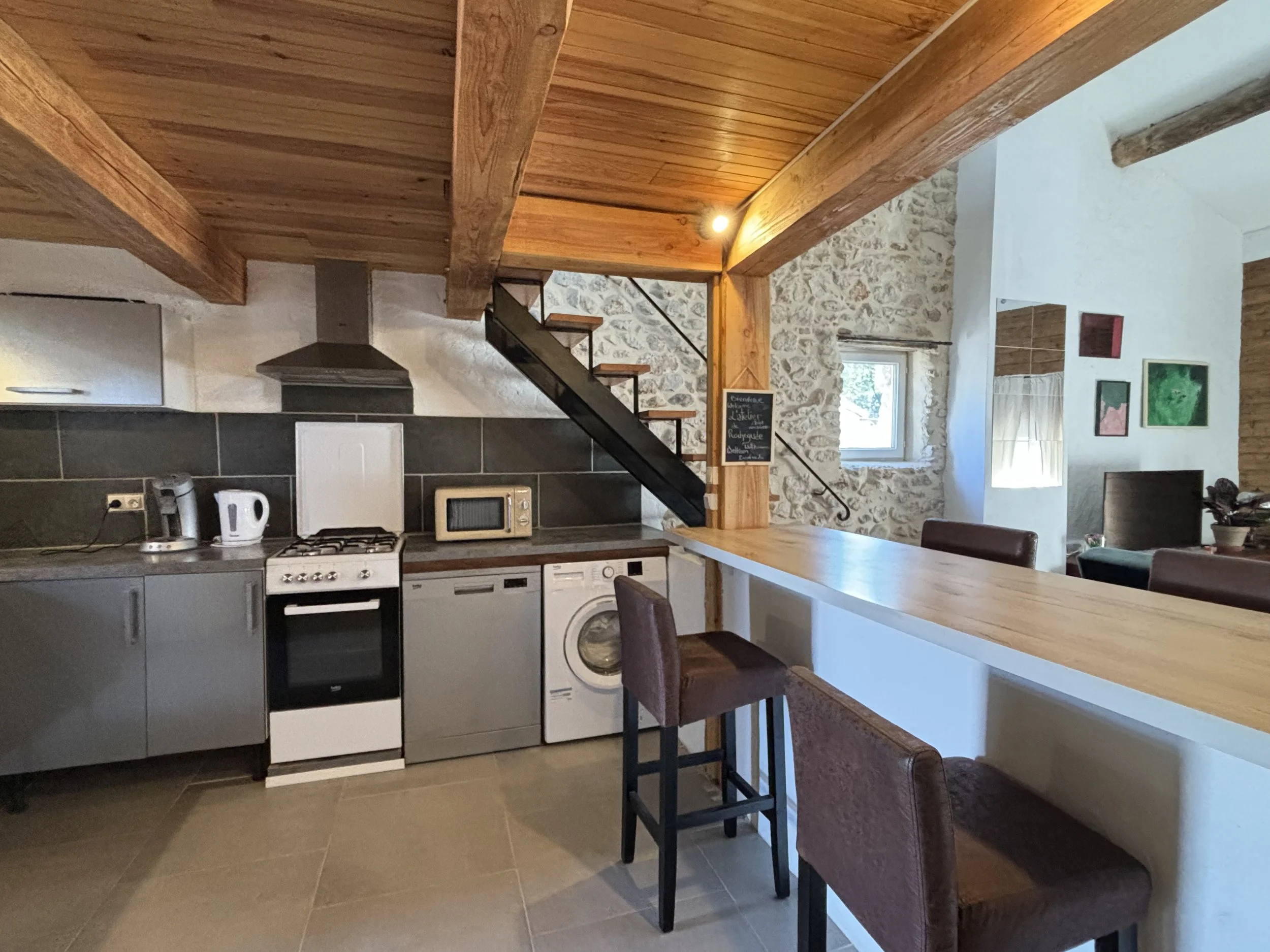 Cuisine tout équipée, Cuisinière et four gaz, lave vaisselle, lave linge, cafetière, bouilloire, théière, micro-onde, frigo, congélateur et bar pour se restaurer.