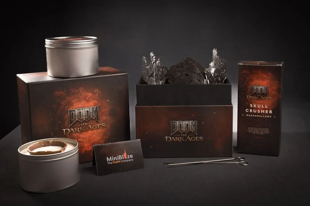 Doom Eternal Dark Ages themed marshmallow roasting kit with metal containers, a box of marshmallows, and a small card from MiniBlaze FirePit Company on a black surface.