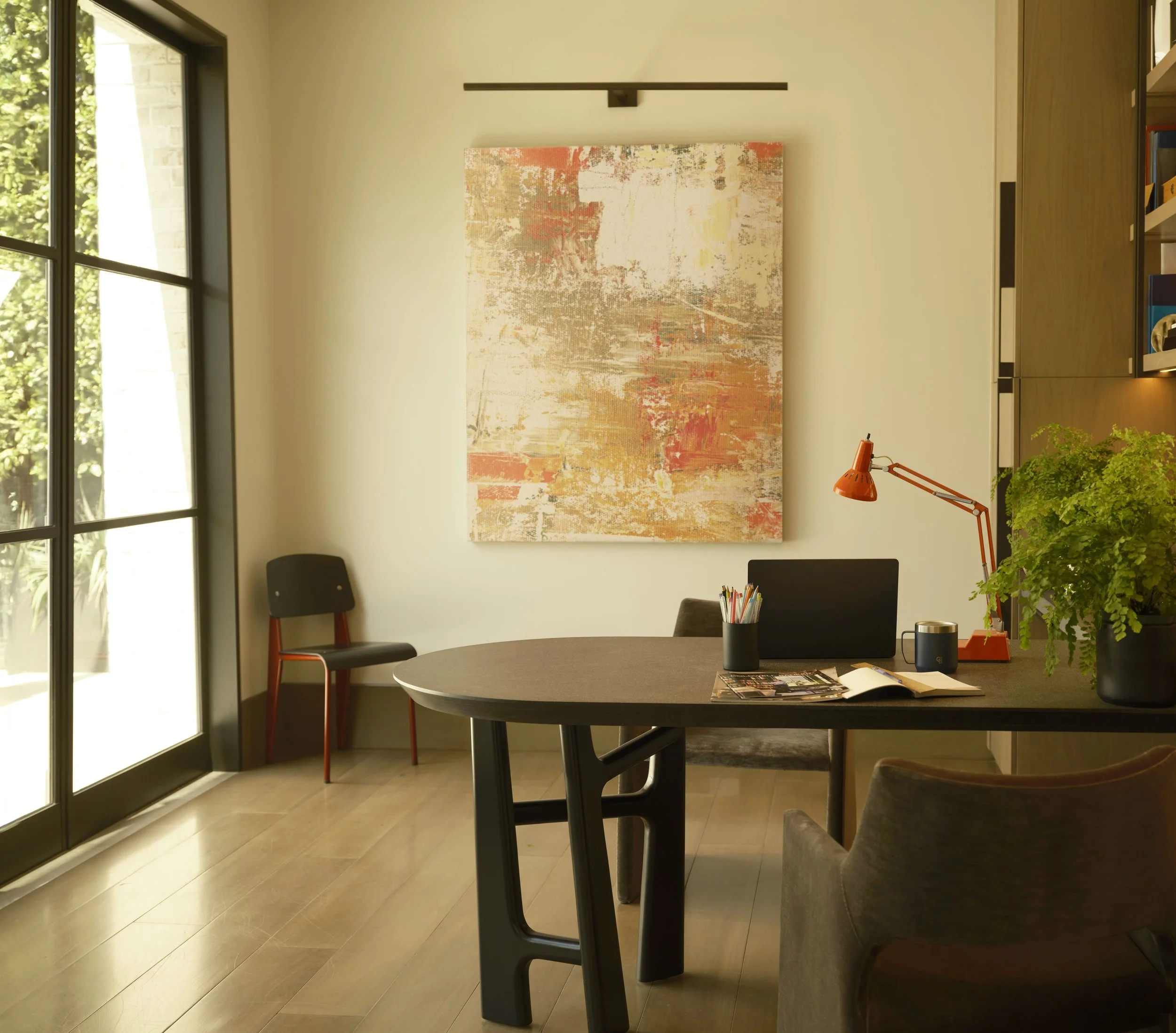 Modern dining room with large window and abstract wall art