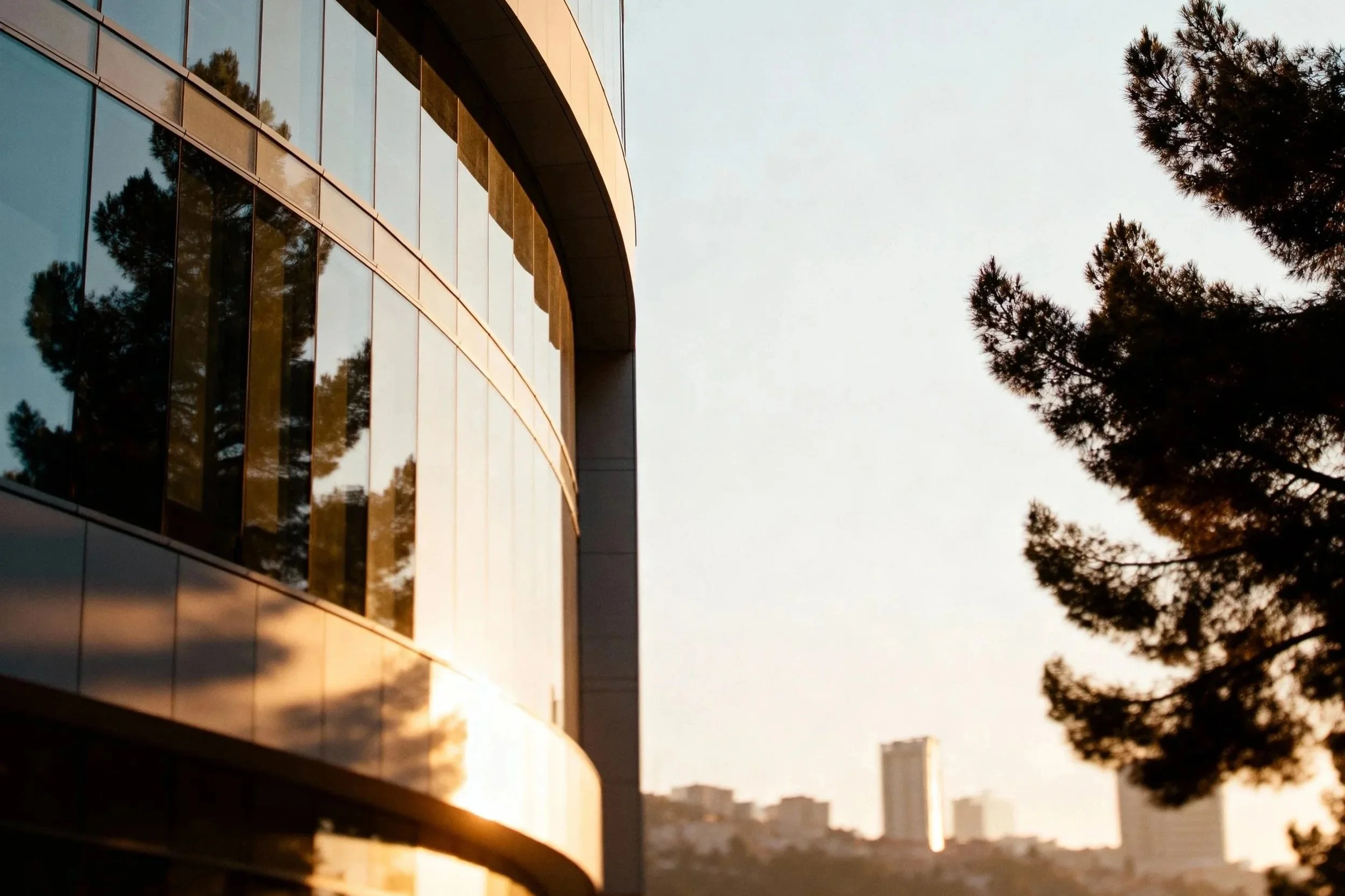 golden-hour-reflections-modern-curved-glass-building.jpg