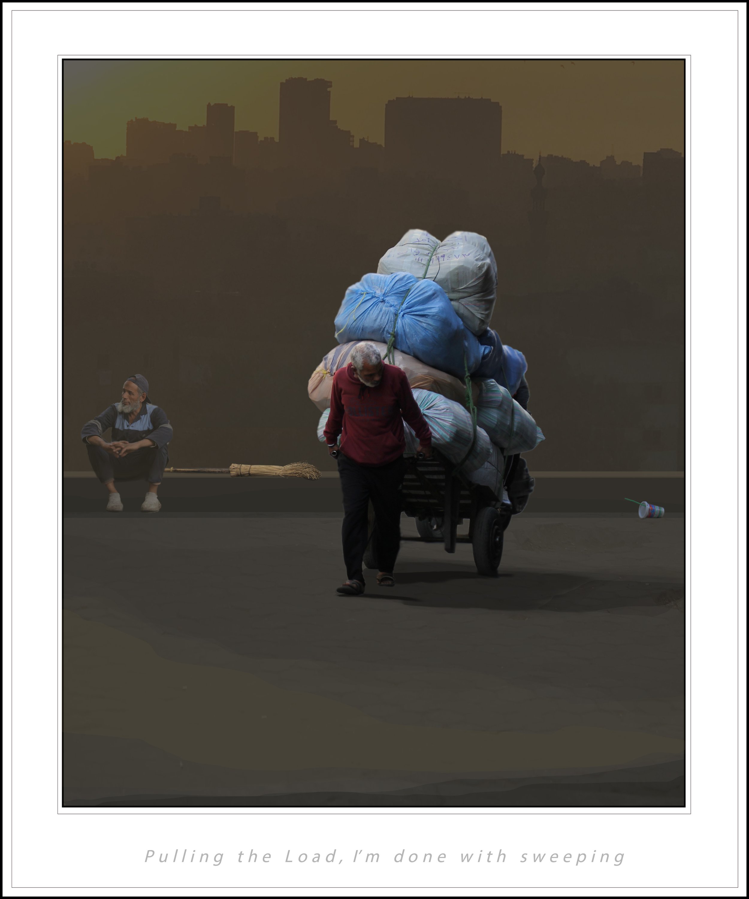 A man pulling a handcart loaded with large bags of belongings along a street at dusk, with a city skyline in the background. A smaller man with a broom is also visible.