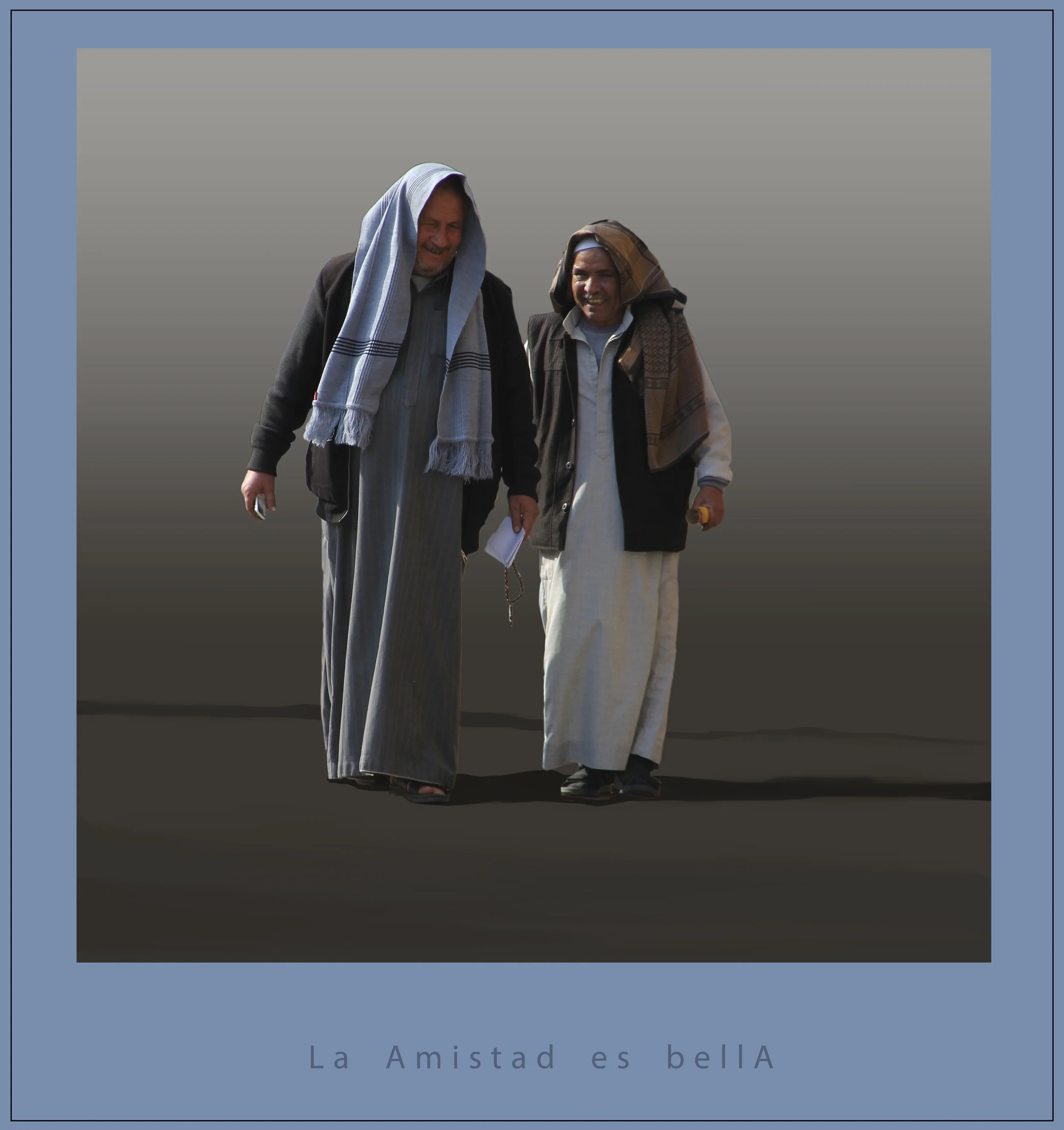 Two men smiling and walking together, wearing traditional Middle Eastern head coverings, with blurred background and a caption in Spanish that says 'La Amistad es bella'.