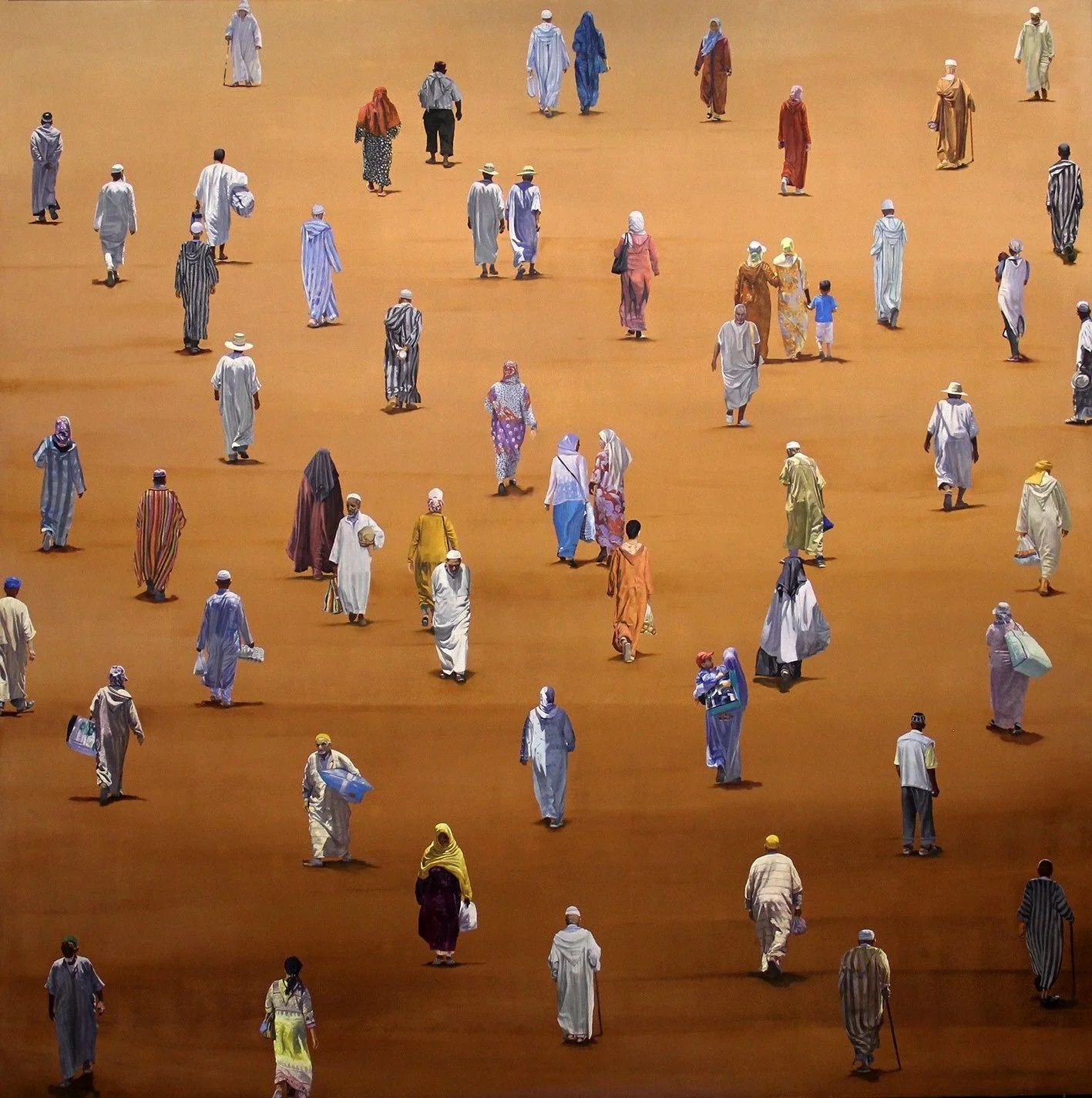 A large group of people dressed in traditional Middle Eastern clothing walking on sandy ground in Morocco.