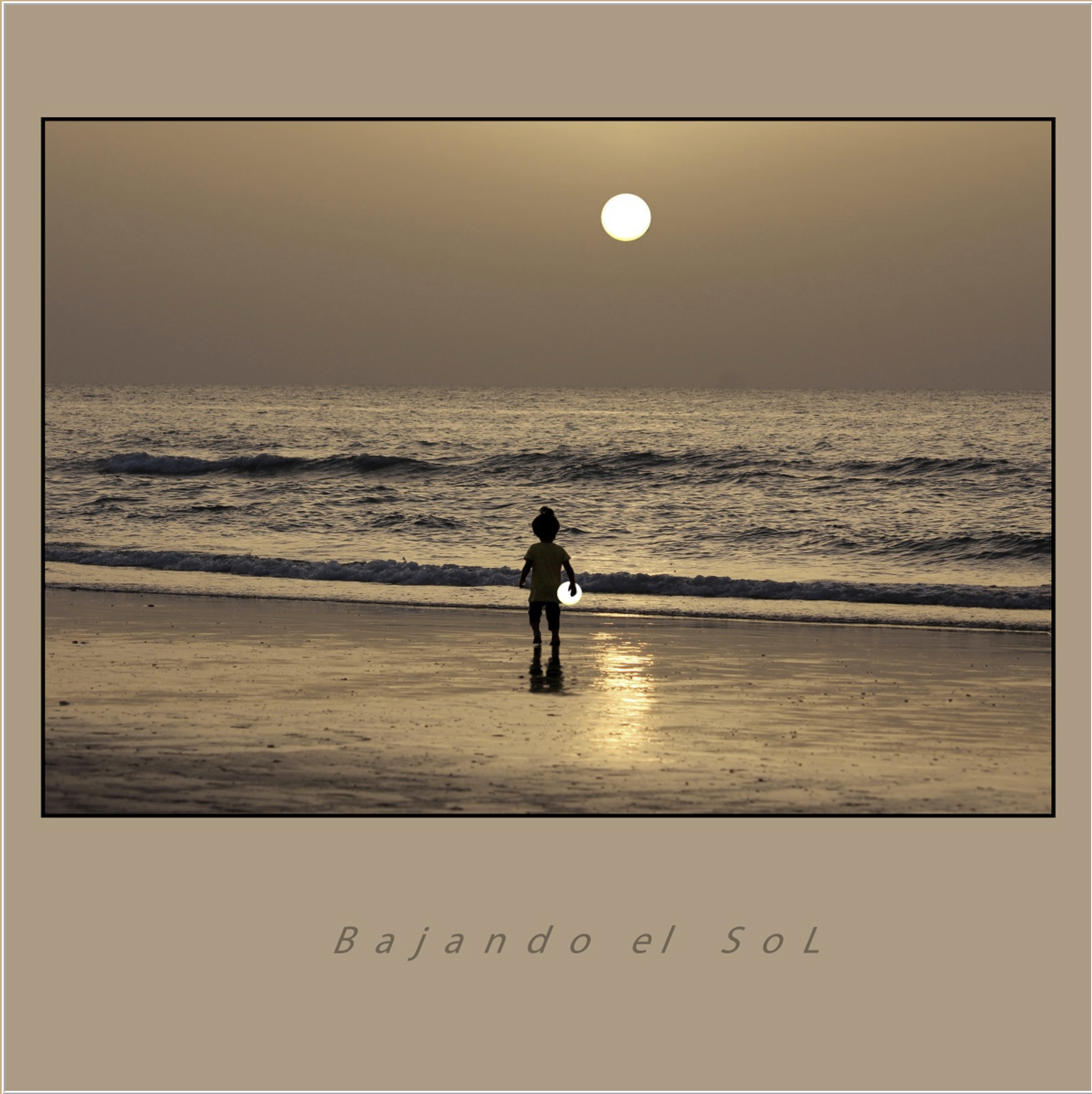 A person walking along the beach at sunset, with the sun low on the horizon over the ocean, creating a calm and serene scene.