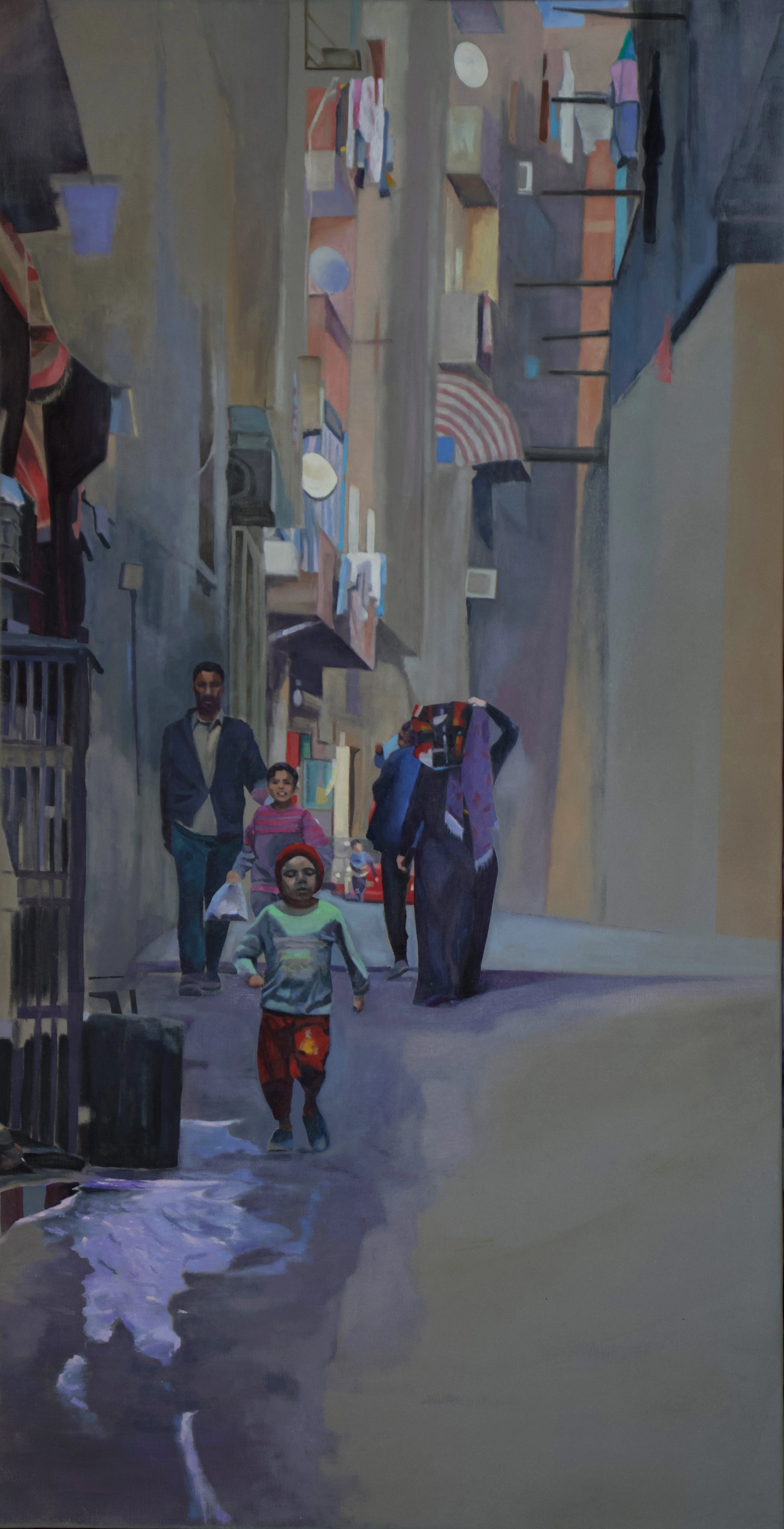 A community street scene painted in a realistic style, showing four people walking through a narrow urban alleyway with building facades that have hanging laundry and various objects. In the foreground, a young boy in a colorful outfit runs through shallow water, followed by a family of three—an adult male, a young girl, and a woman with a headscarf and hand on her head.