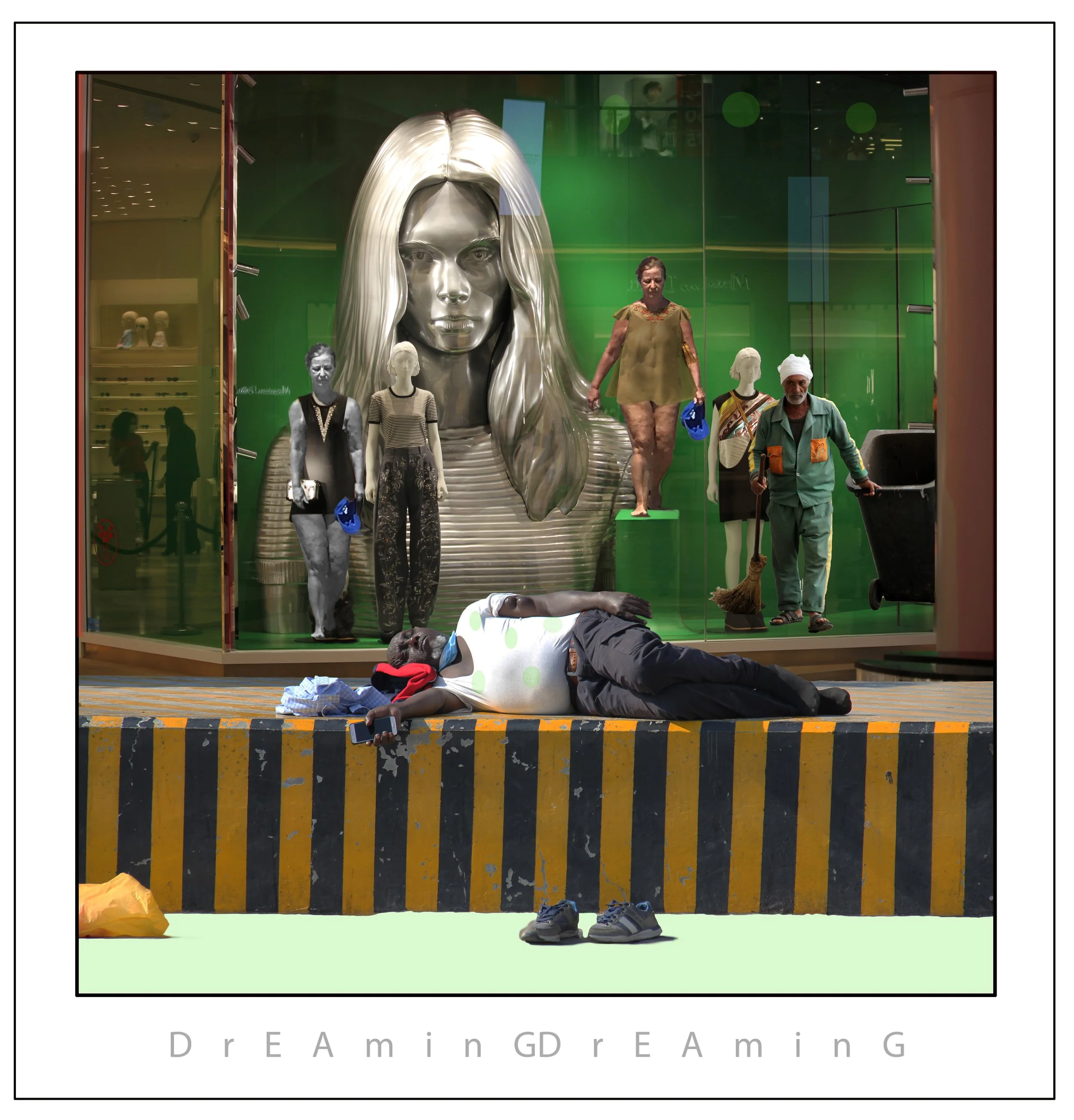 A store window display with a large metallic statue of a woman's head with long hair, surrounded by mannequins dressed in casual clothing, and two people standing in front. Two individuals are walking by outside the store, one with a broom and another holding a phone. The store window has a green backdrop and reflection of the shopping mall.