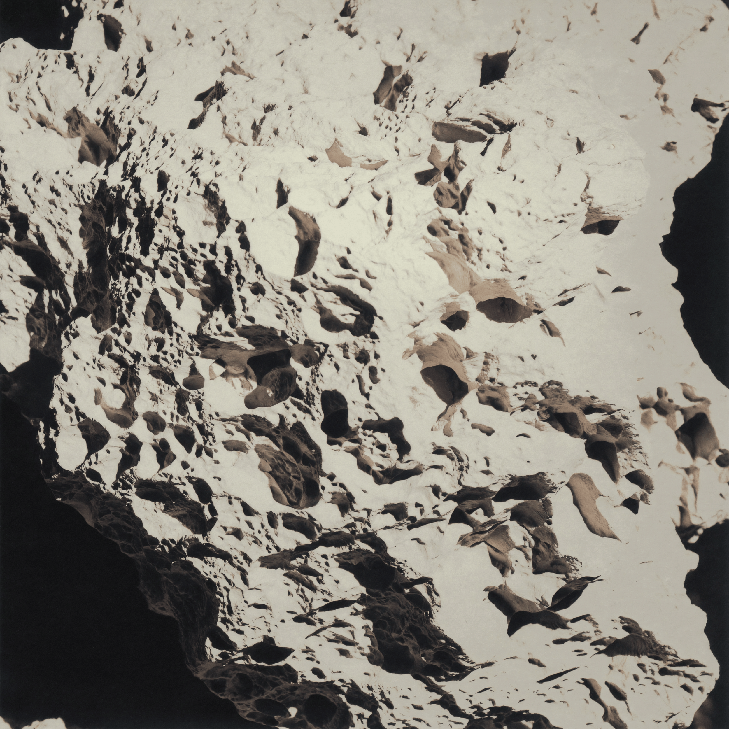 A mountain landscape showing snow-covered peaks under a clear sky.