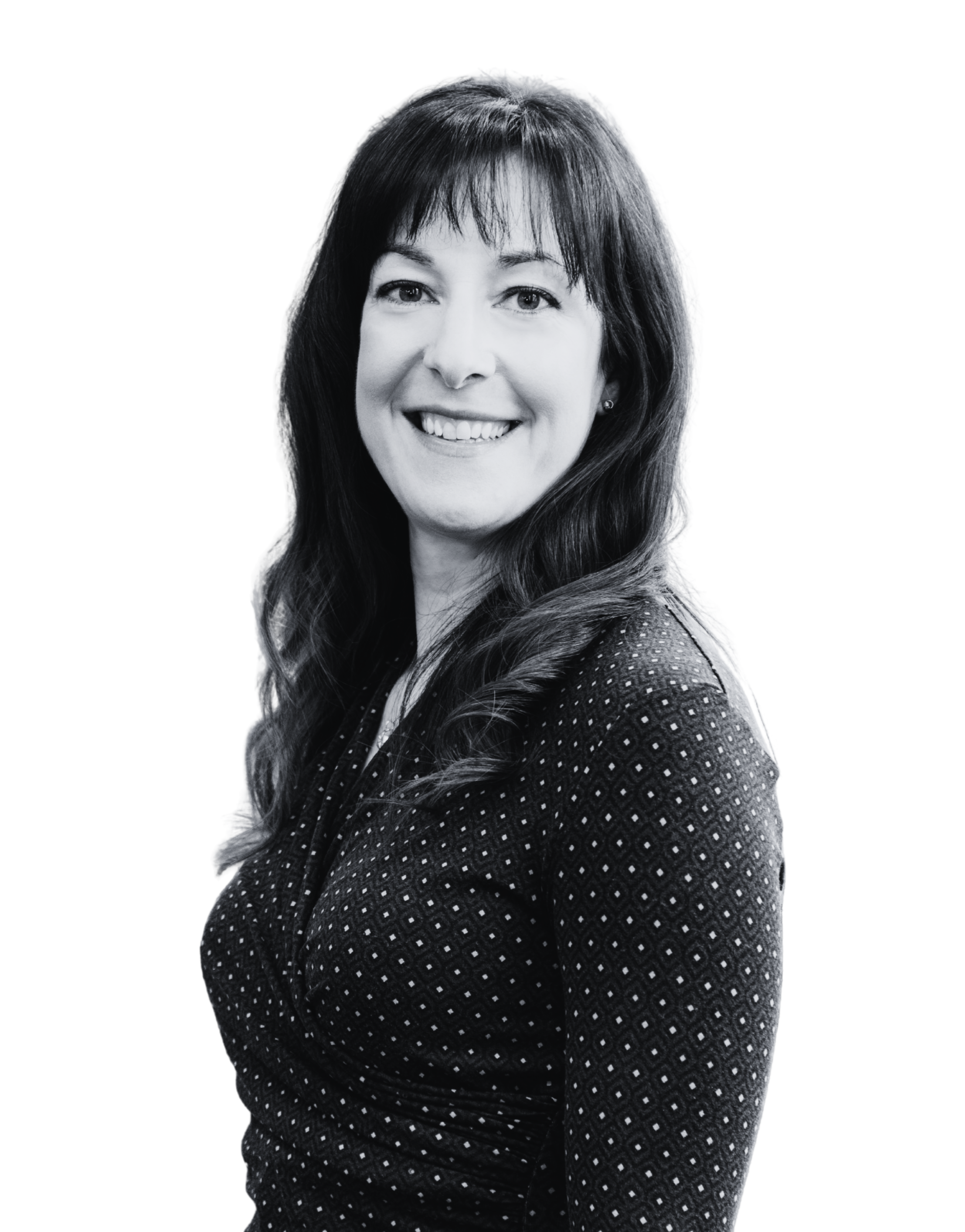 Black-and-white portrait of a woman with long wavy hair, smiling, wearing a dotted blazer.