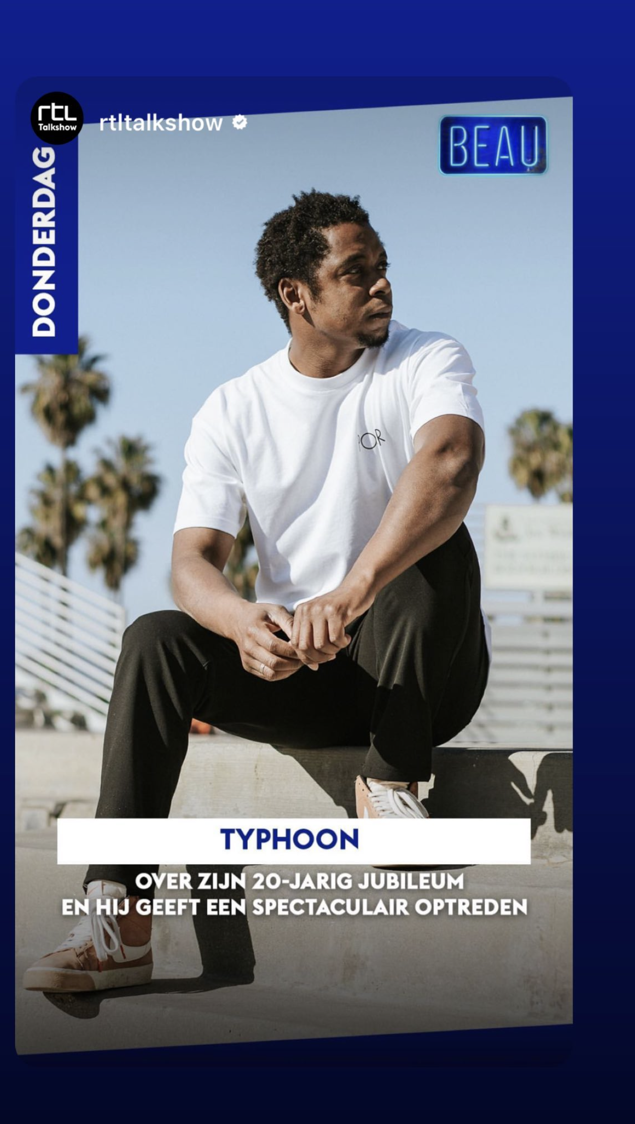 A man sitting outdoors on a concrete ledge, wearing a white t-shirt and black pants, with palm trees and a blue sky in the background. The image includes text indicating a feature about Typhoon, celebrating his 20th anniversary, on a show called RTL Talkshow.