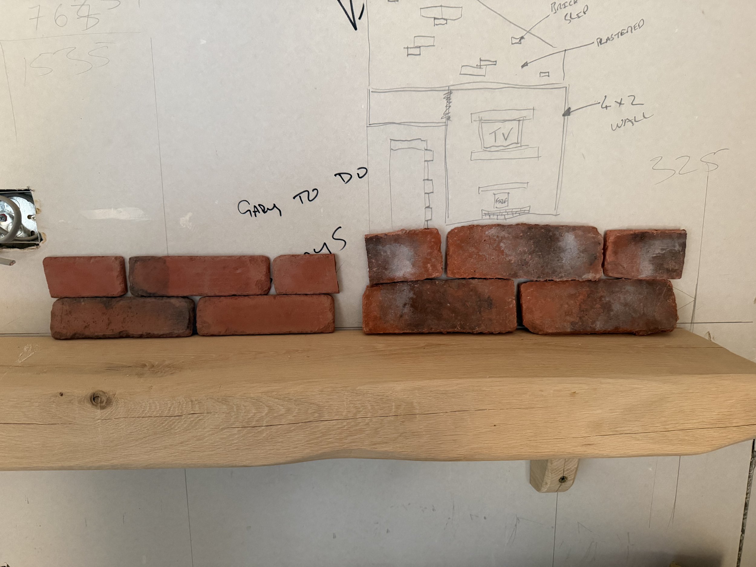 Sketch of a room layout with annotations, placed above a row of red bricks and a wooden plank surface.