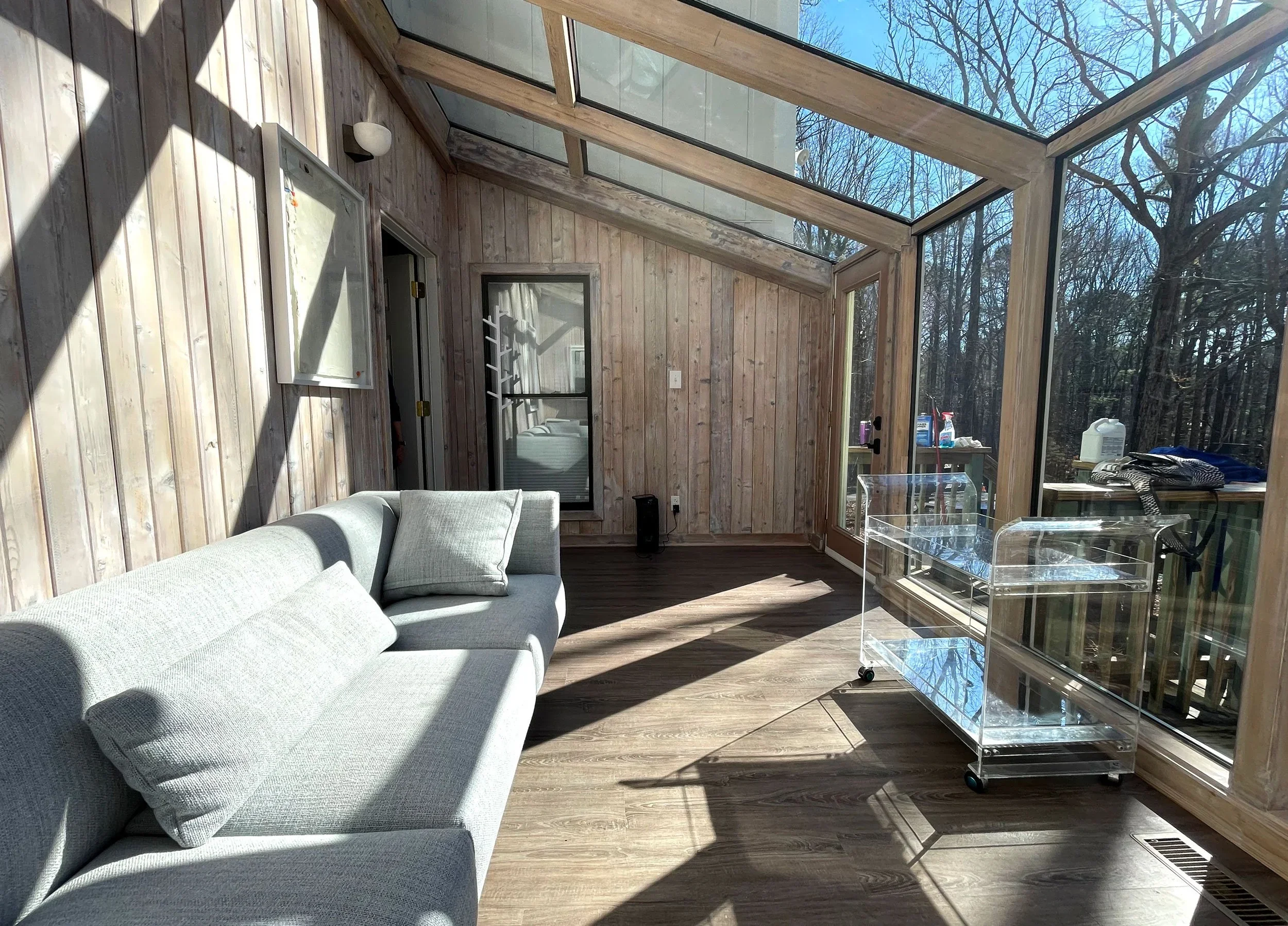A cozy 1970's sunroom re-styled to modernize and brighten the sunlit enclosed porch.