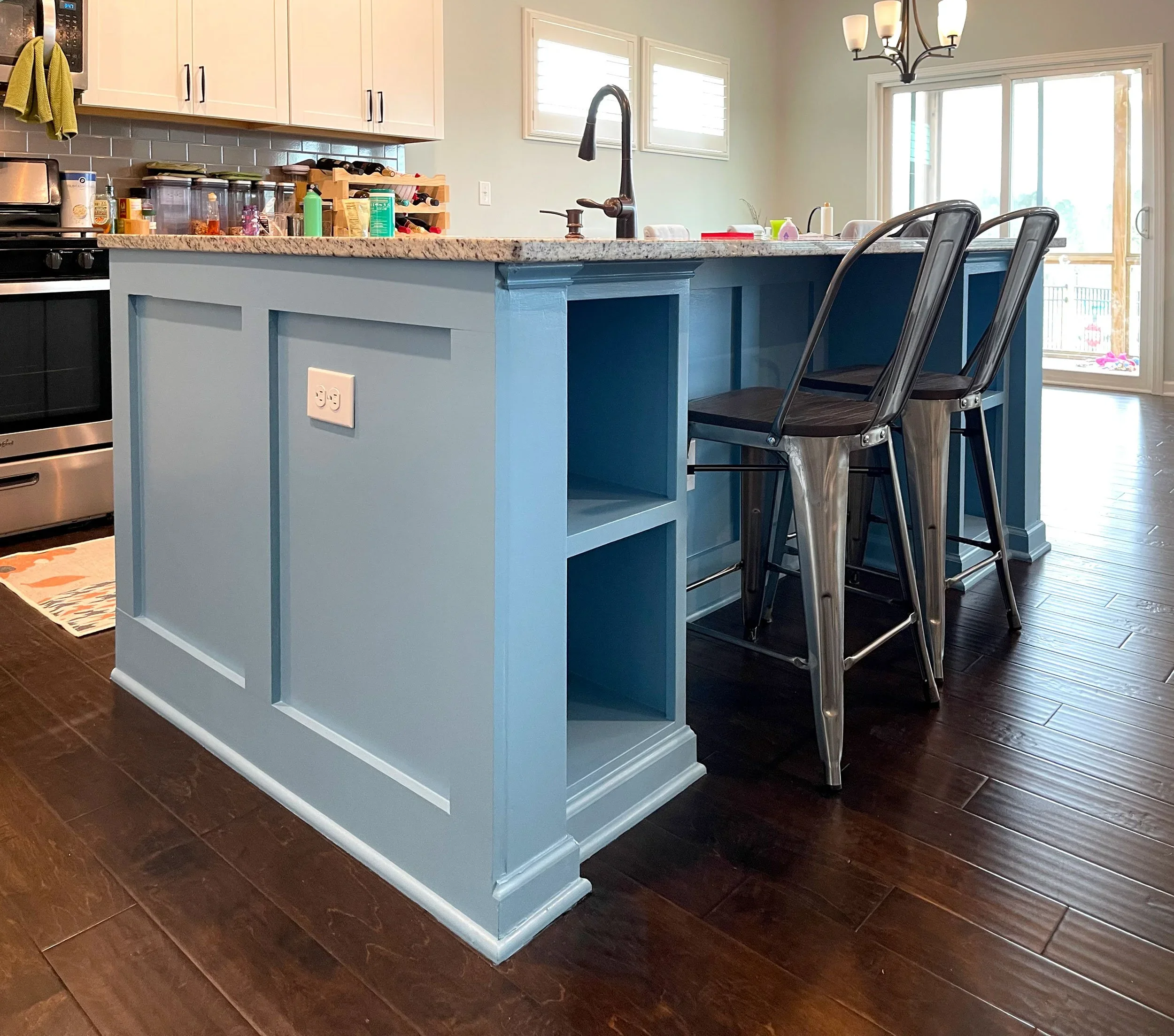 New construction kitchen styled with a blue island to tie the open plan room together.