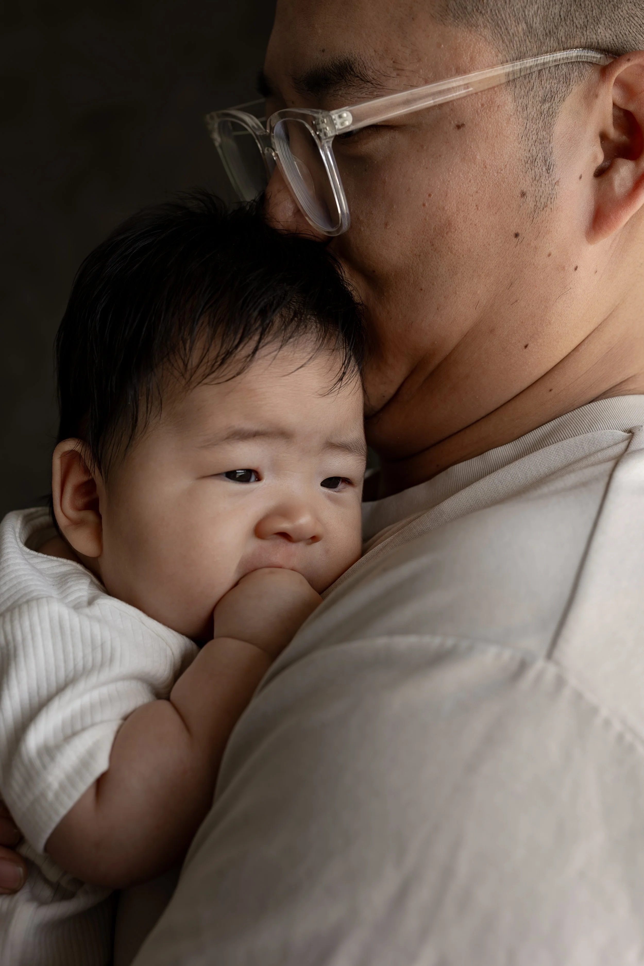 Baby cuddled against their parent during an Adelaide newborn family photography session.