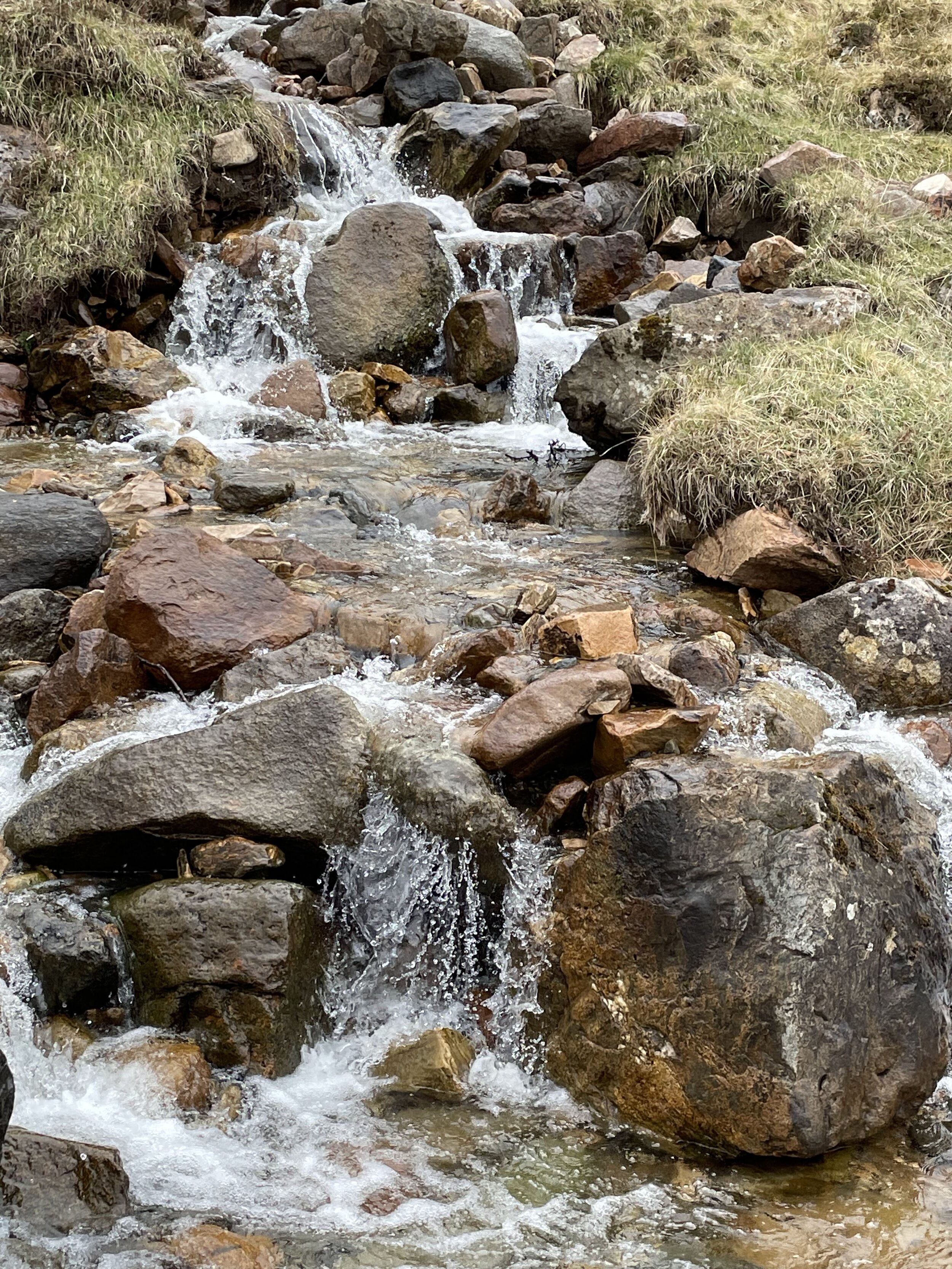 a waterfall flows across rocks and stones