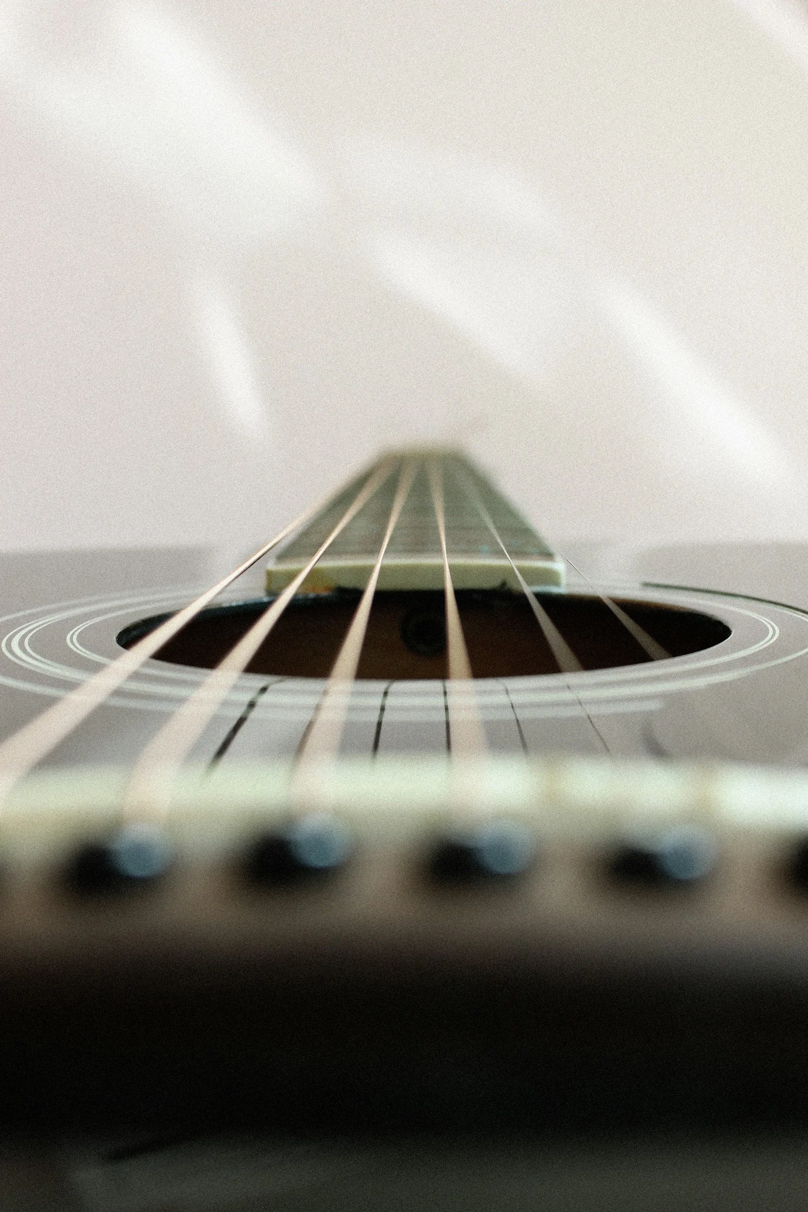 Close-up view of a guitar viewed from the body looking up toward the neck and headstock.