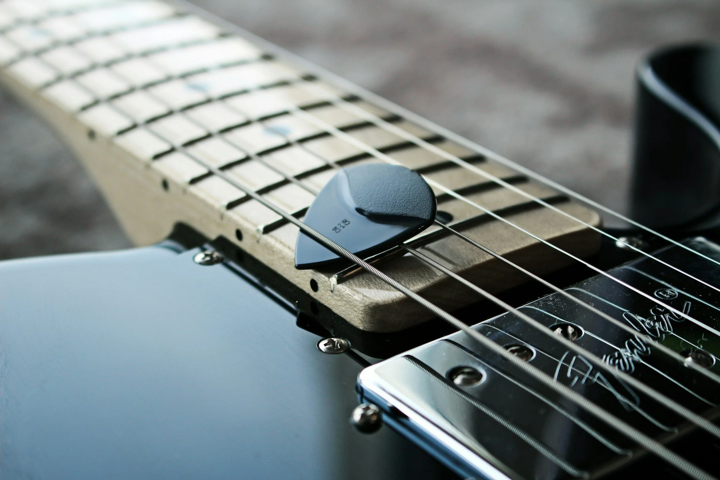Close-up of an electric guitar with a focus on the pickups, strings, and part of the fretboard.