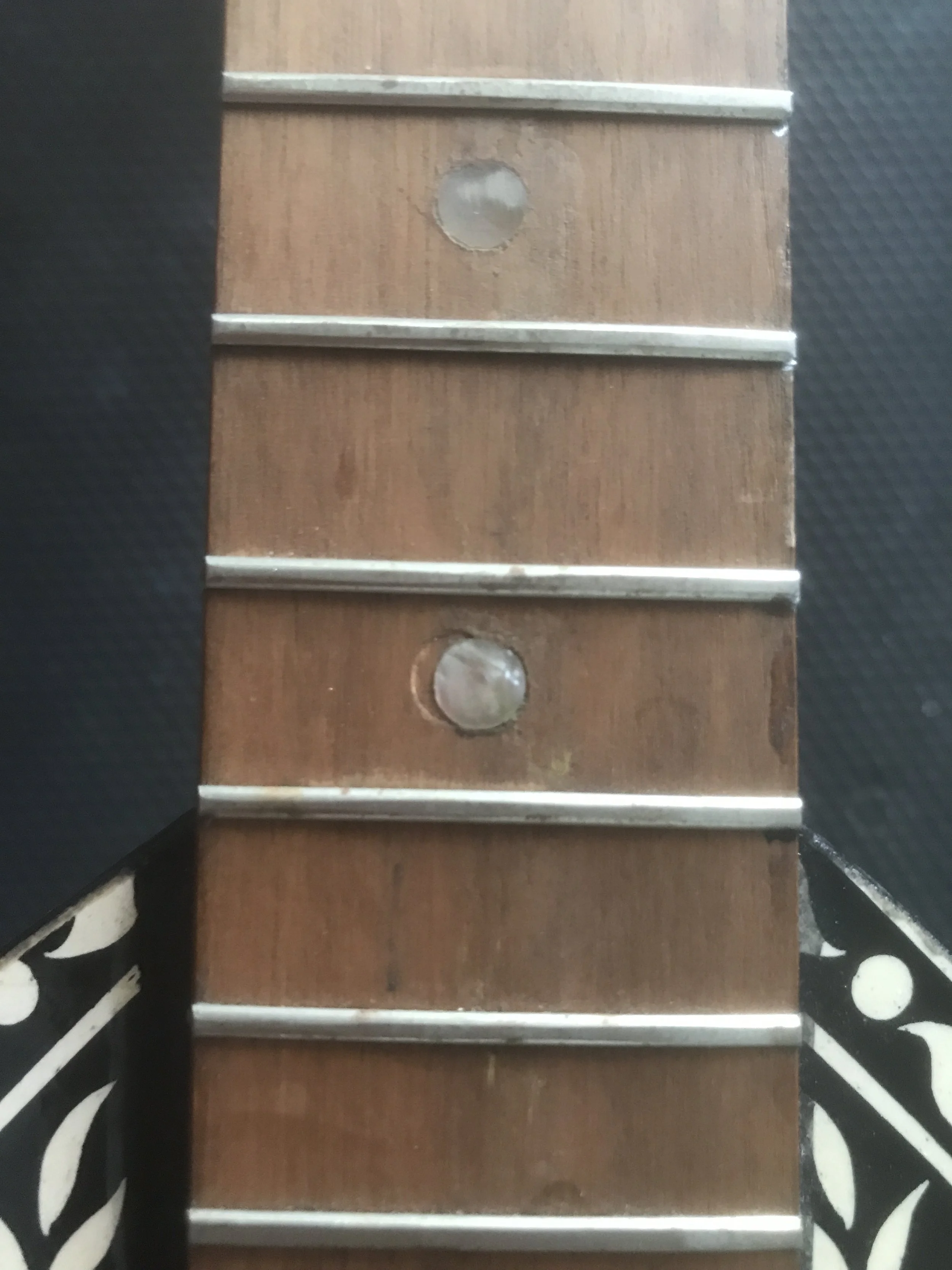 Part -1- A close-up of a wooden guitar that needs spot leveling, cleaning, and polishing.