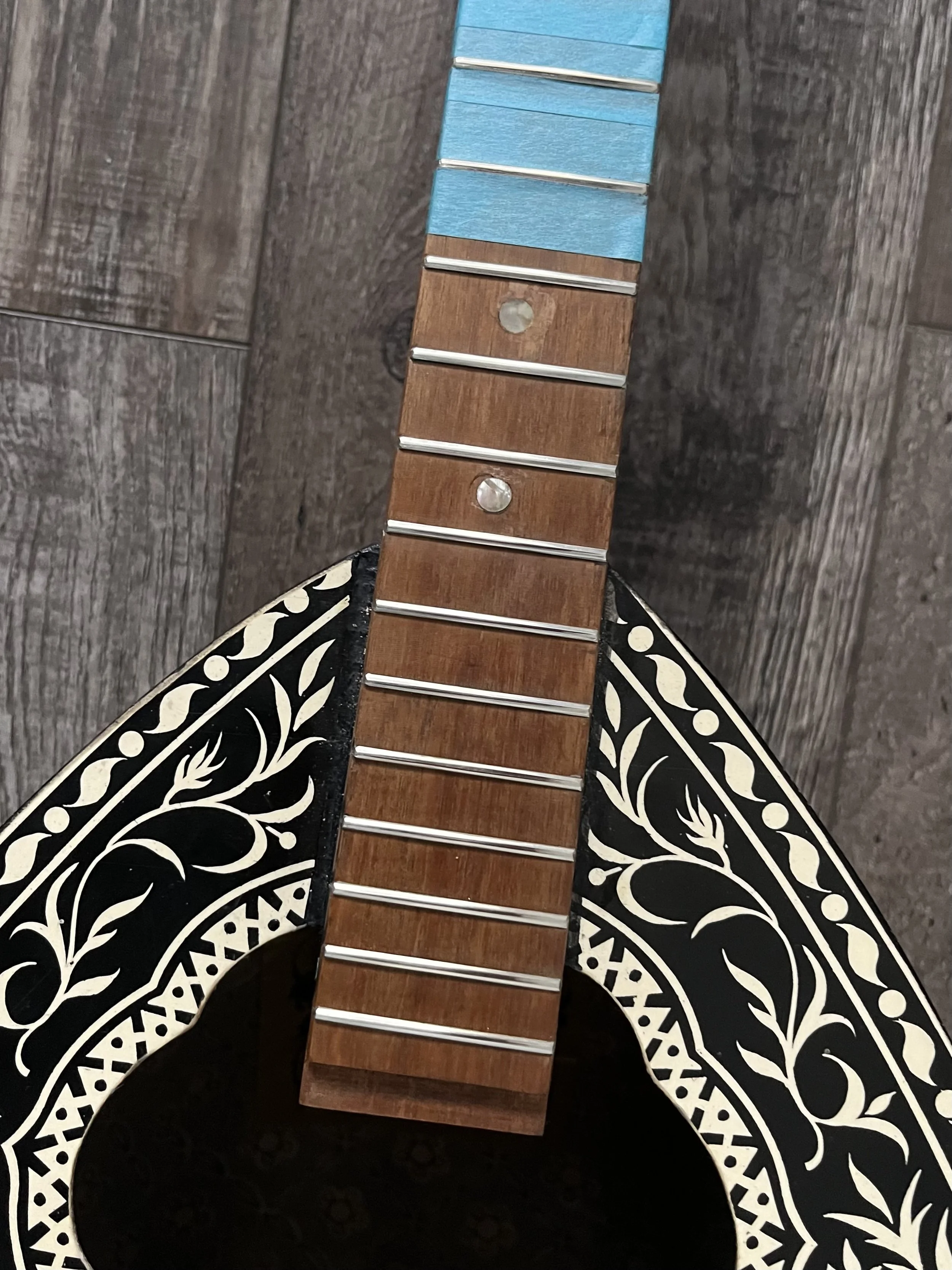 Part -2- A close-up of a wooden guitar that has spot levelling, cleaning, and polishing.