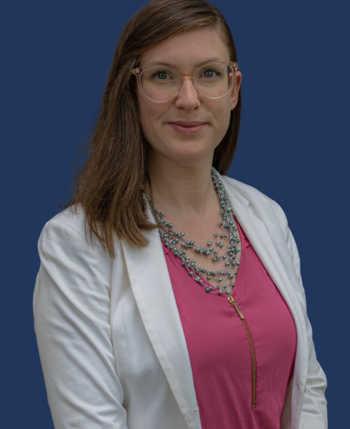 Kayla Thompson-Riviere, Registered Nurse and Personal Medical Strategist, smiling in a white jacket, pink blouse, and beaded necklace