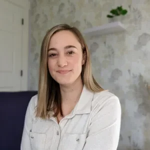 Lexi Gross, Licensed Clinical Mental Health Counselor, smiling in a cream button-up shirt.