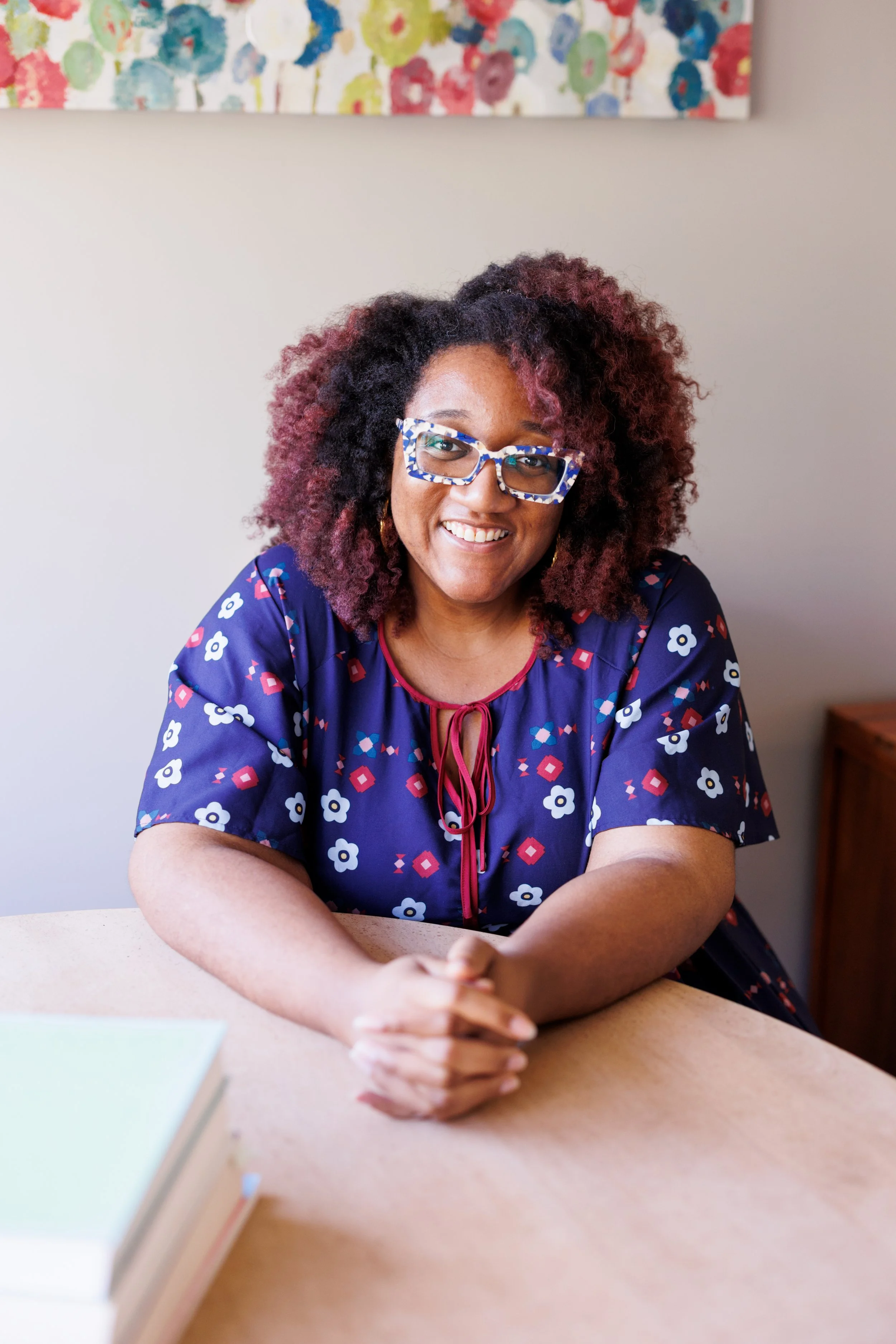 Shakira O'Garro, Licensed Professional Counselor, smiling in a patterned blue blouse, sitting at a table