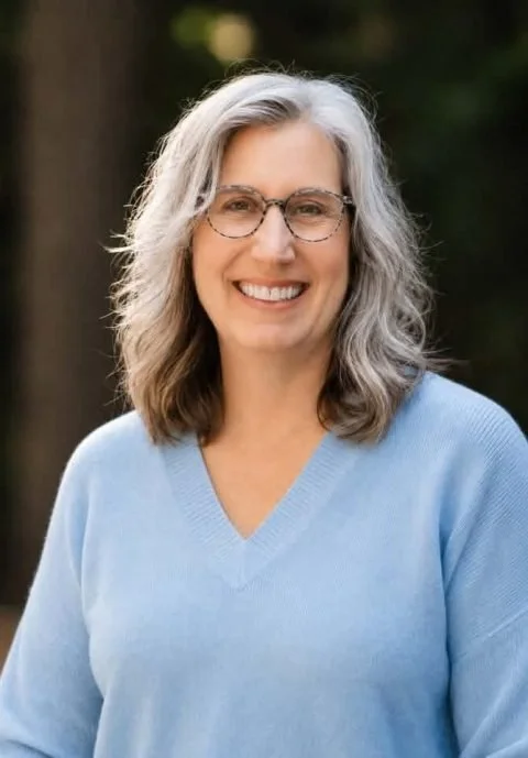 Maureen Kane, Licensed Mental Health Counselor, smiling in a light blue V-neck sweater outdoors