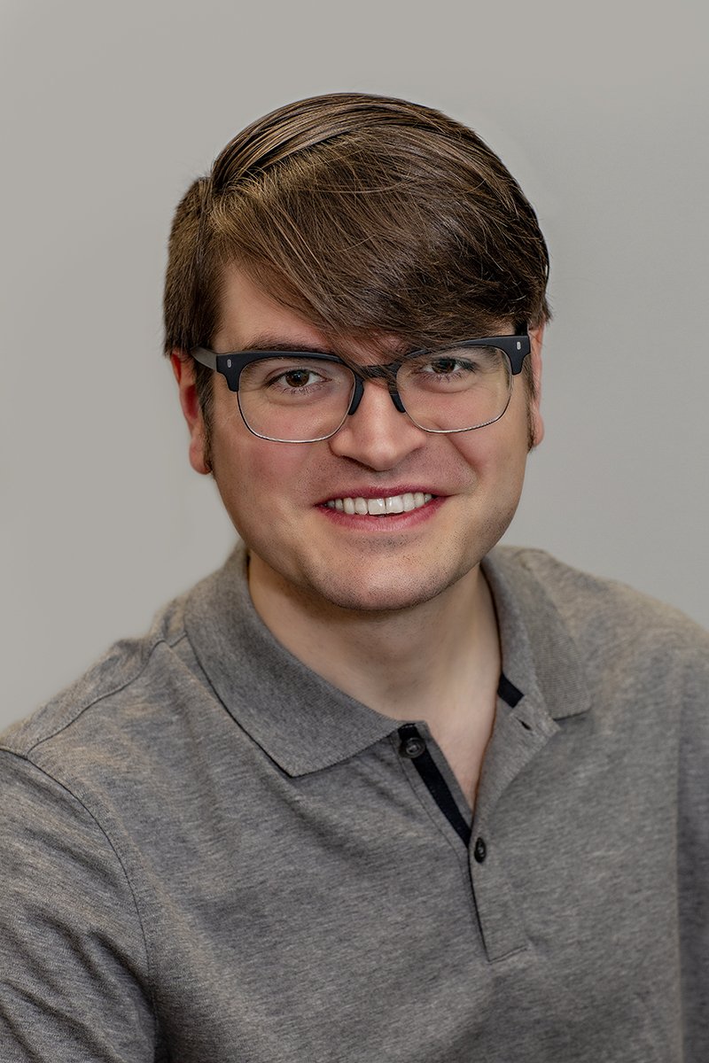 Mark Flanagan, Licensed Clinical Social Worker, smiling in a heather gray polo shirt set against a neutral light gray background