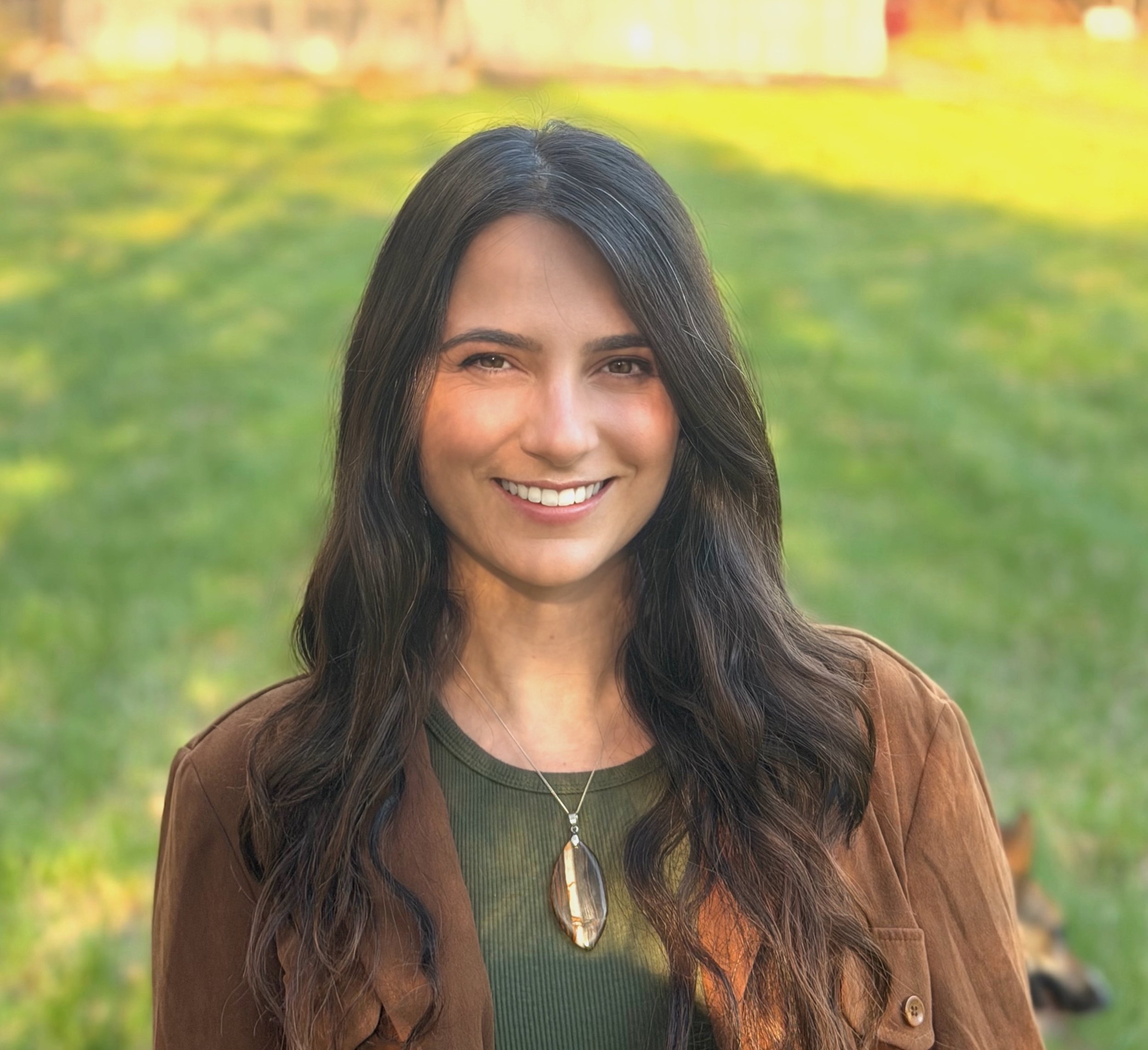 Lauren Traitz, Licensed Marriage and Family Therapist, smiling in a brown jacket and olive green top outdoors