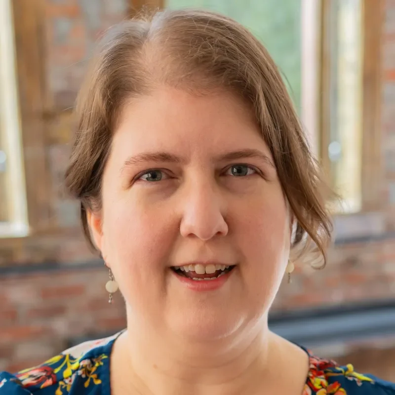 Christy Reichart, Licensed Independent Clinical Social Worker, smiling in a blue floral shirt indoors