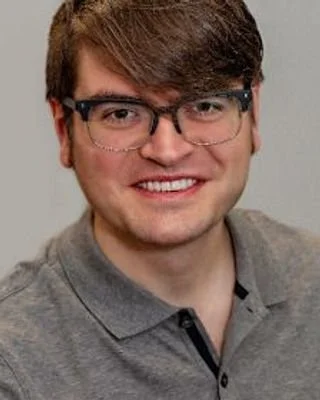 Mark Flanagan, Licensed Clinical Social Worker, smiling in a grey collared shirt
