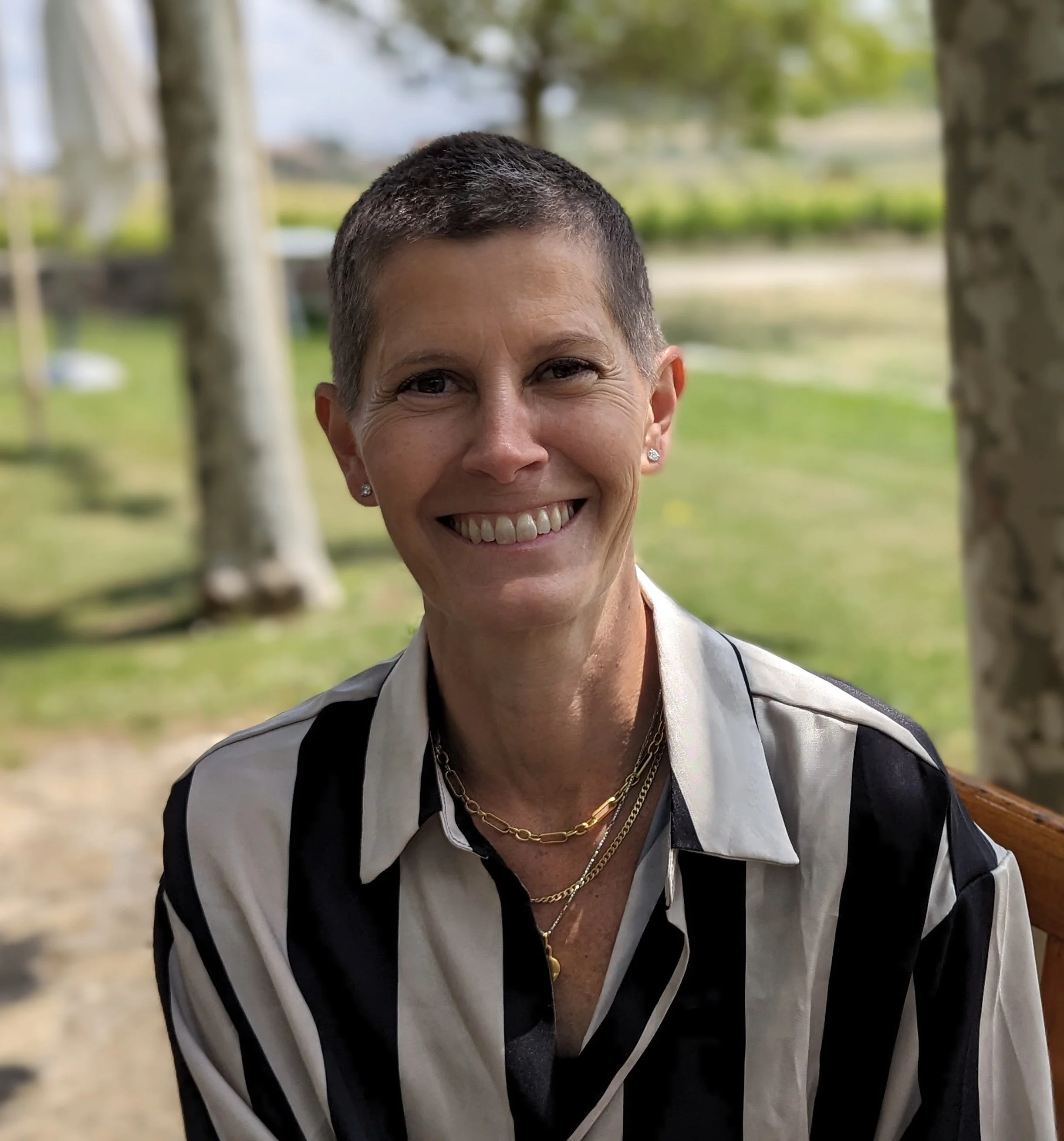 Aimee Jordan, Licensed Clinical Psychologist, smiling in a black and white striped shirt in a sunny outdoor setting