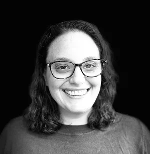 Annie Brashem, licensed mental health therapist, smiling wearing eyeglasses and a crewneck shirt