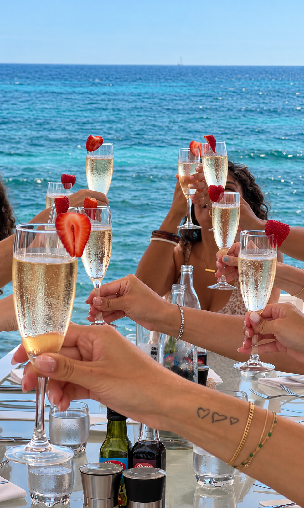 Women celebrating with champagne on a terrace overlooking the sea during a private group retreat in Mallorca