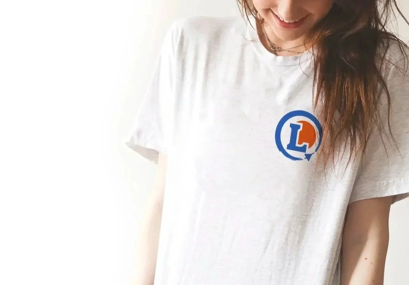 Personne portant un t-shirt blanc avec un logo multicolore L.