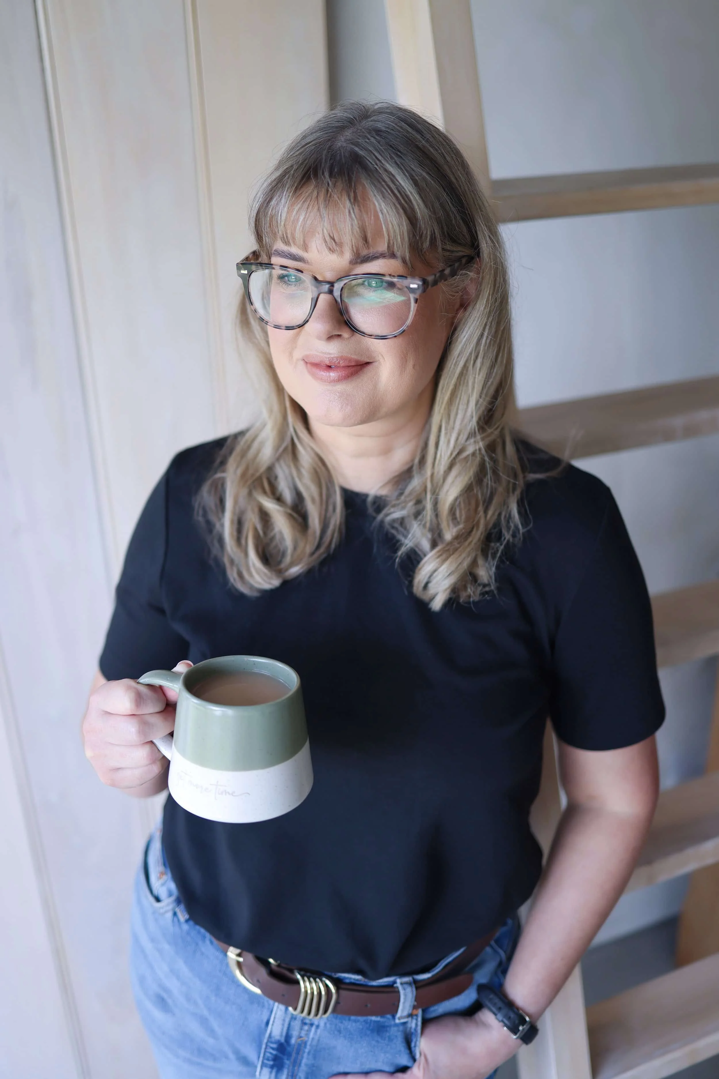 sarah stewart smiling whilst holding a cup of tea