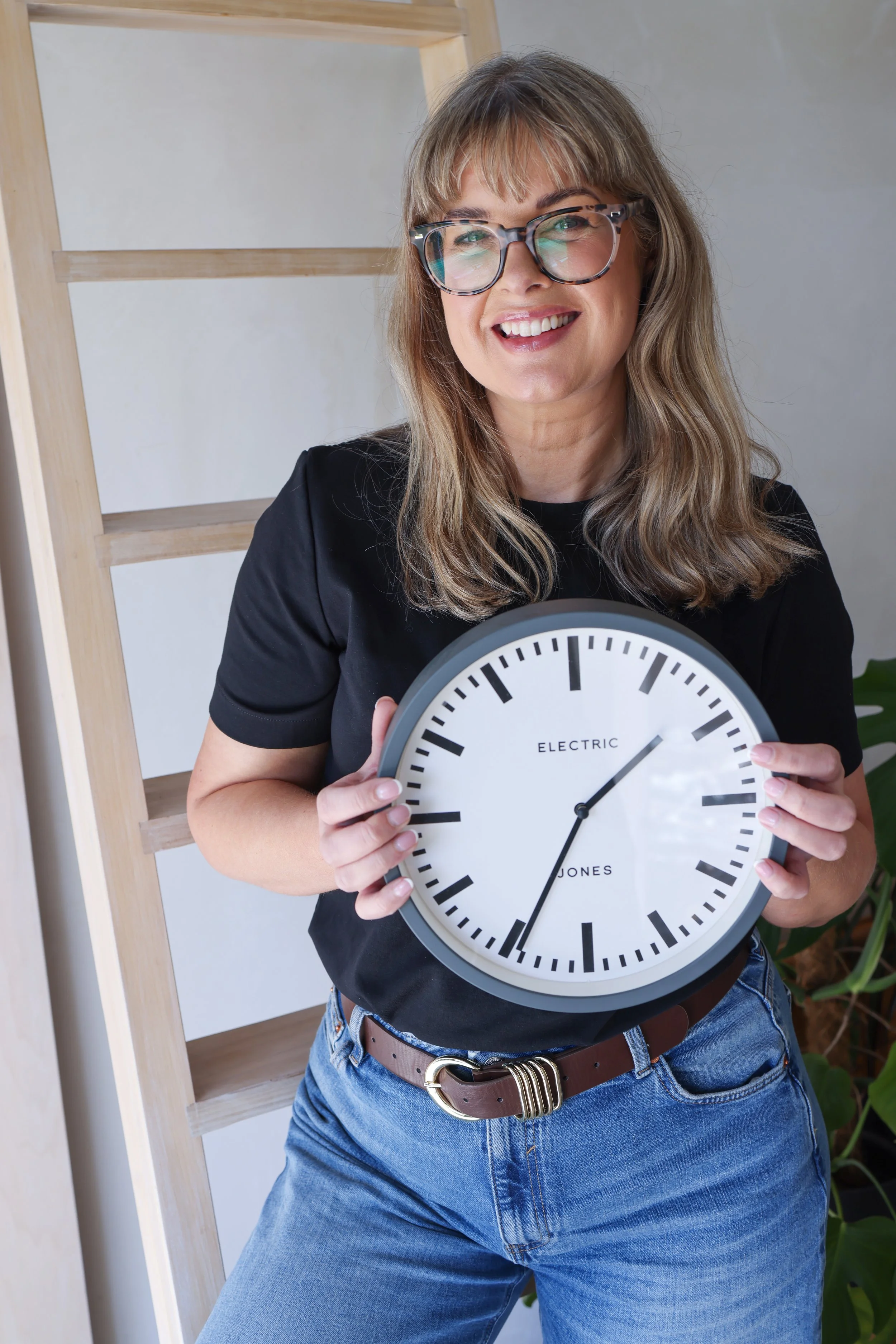 Sarah Stewart time and project management expert smiling whilst holding a clock