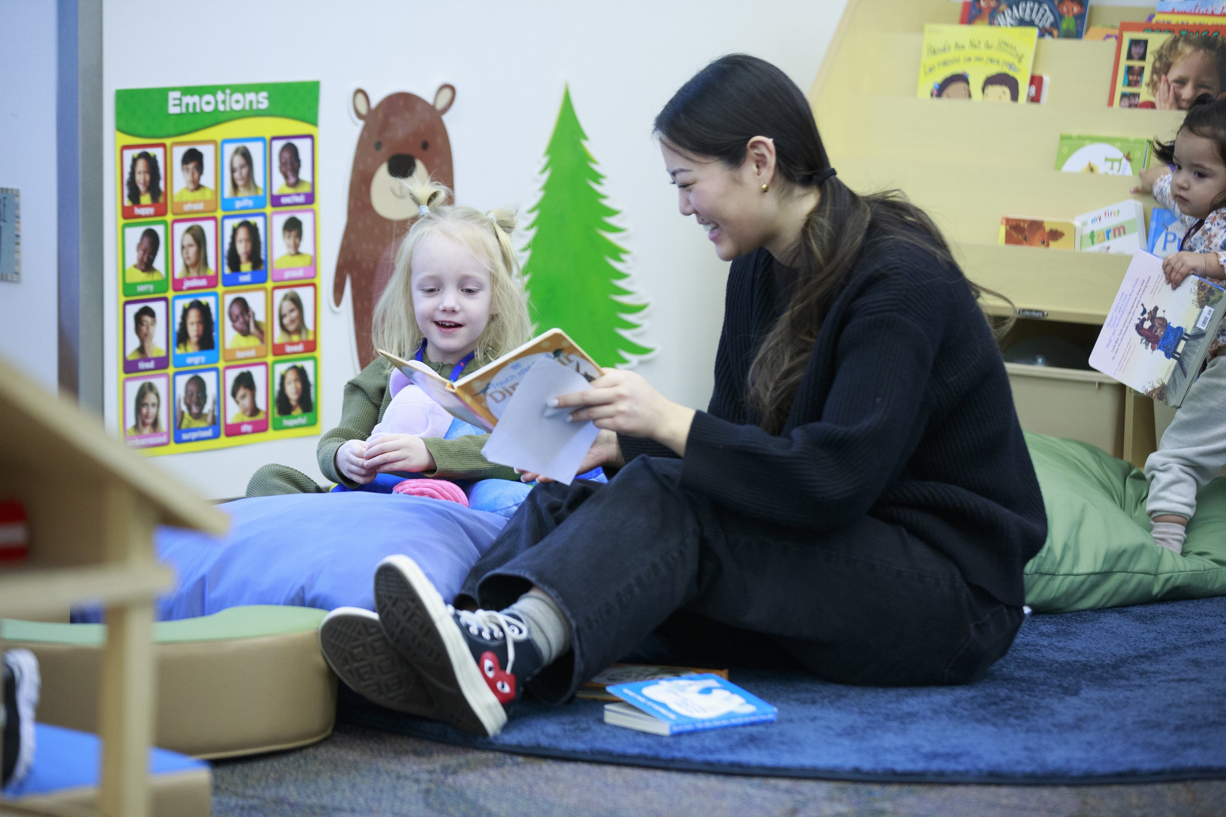 Volunteer reading a story to a toddler