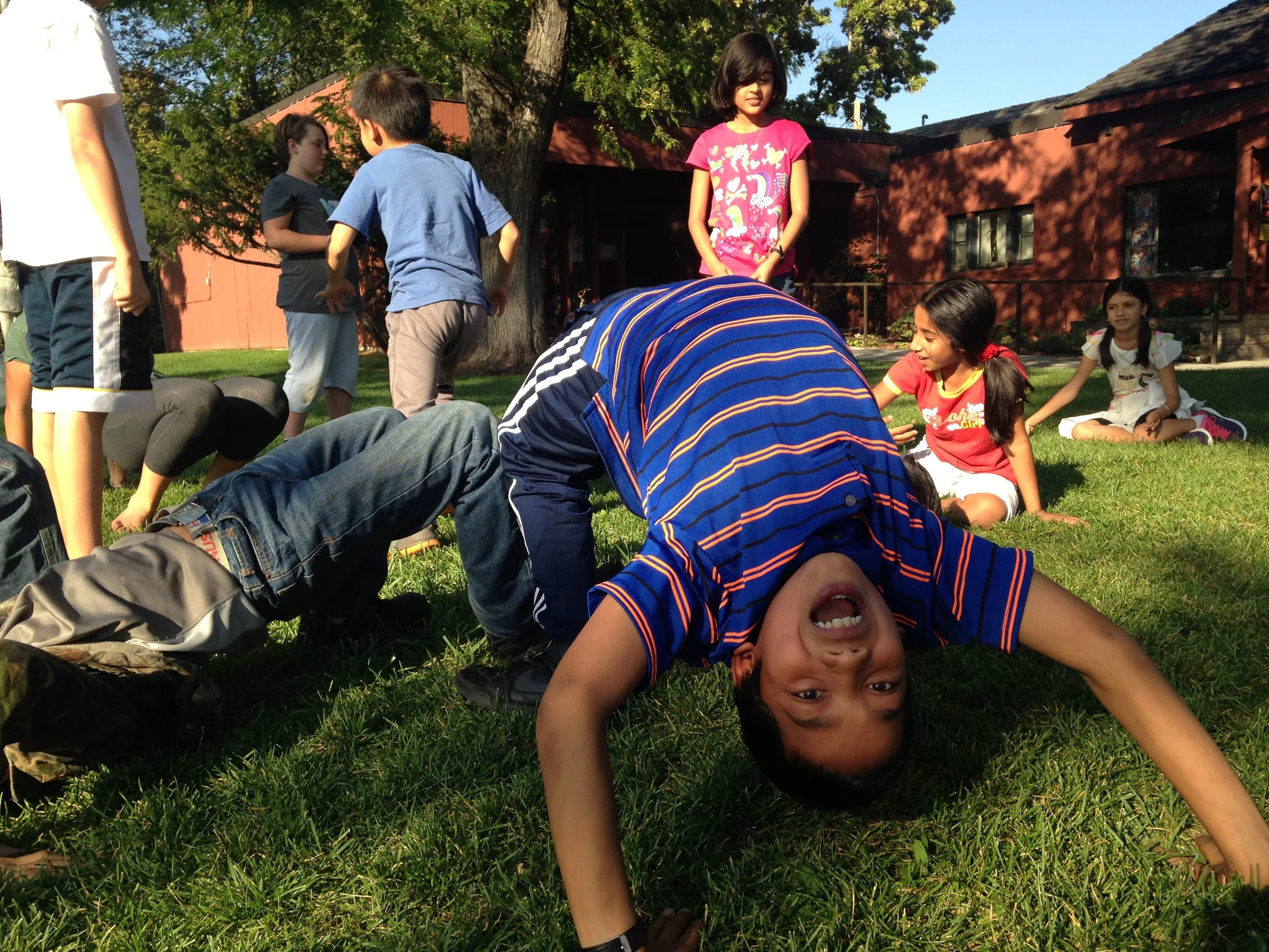 Kid playing outside doing a backbend.