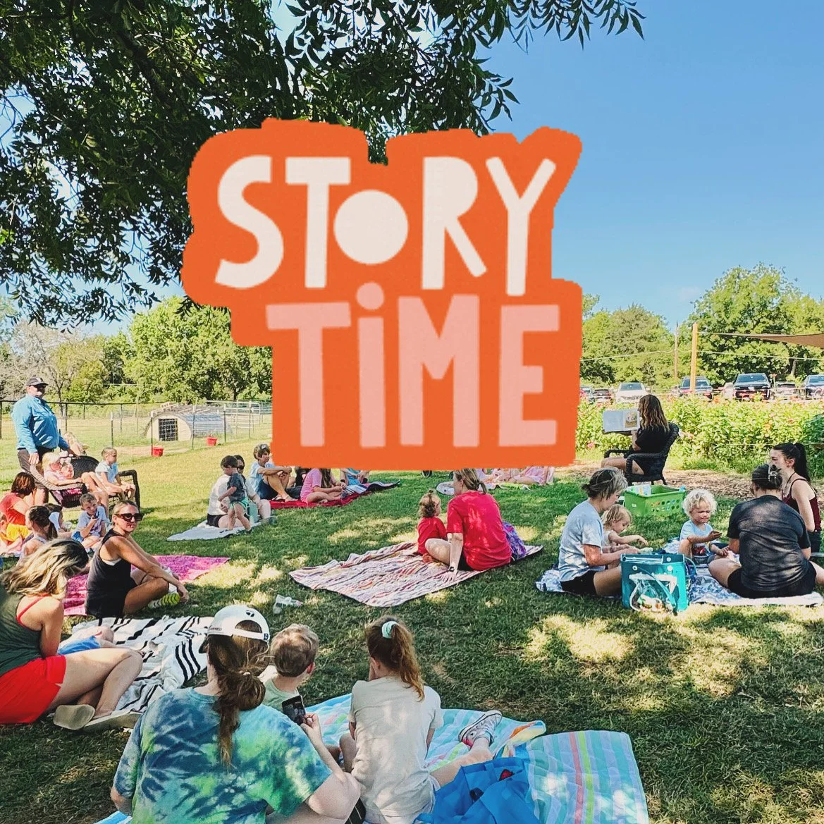 A group of children and adults sitting on blankets and chairs outdoors on a sunny day, with a farmer reading a book, under a tree.  Story Time at The Flower Meadow Flower Farm in Coweta, Ok