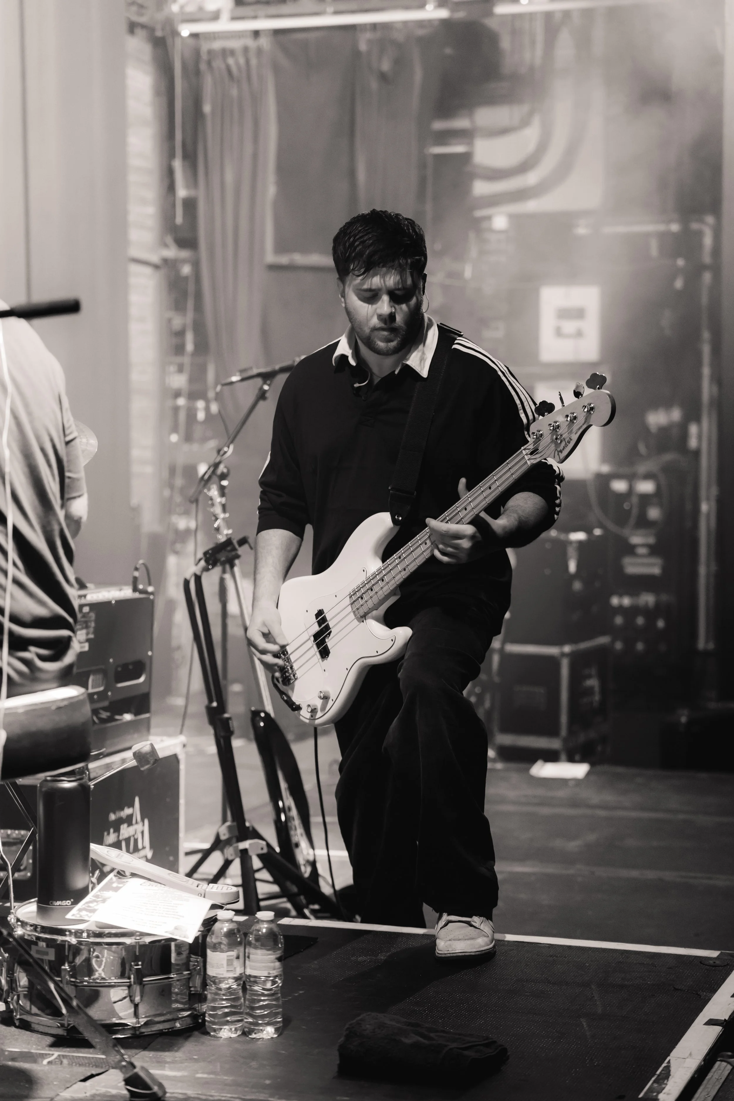 Guitar teacher playing a bass guitar on stage during a live performance.