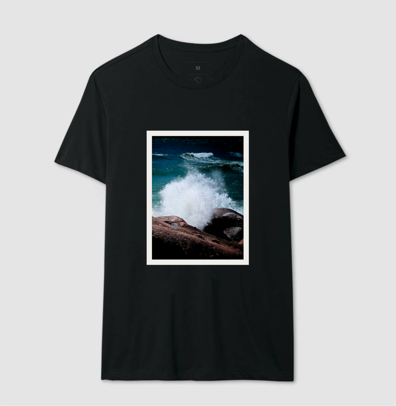 camiseta preta com foto de ondas do mar quebrando na rocha na frente