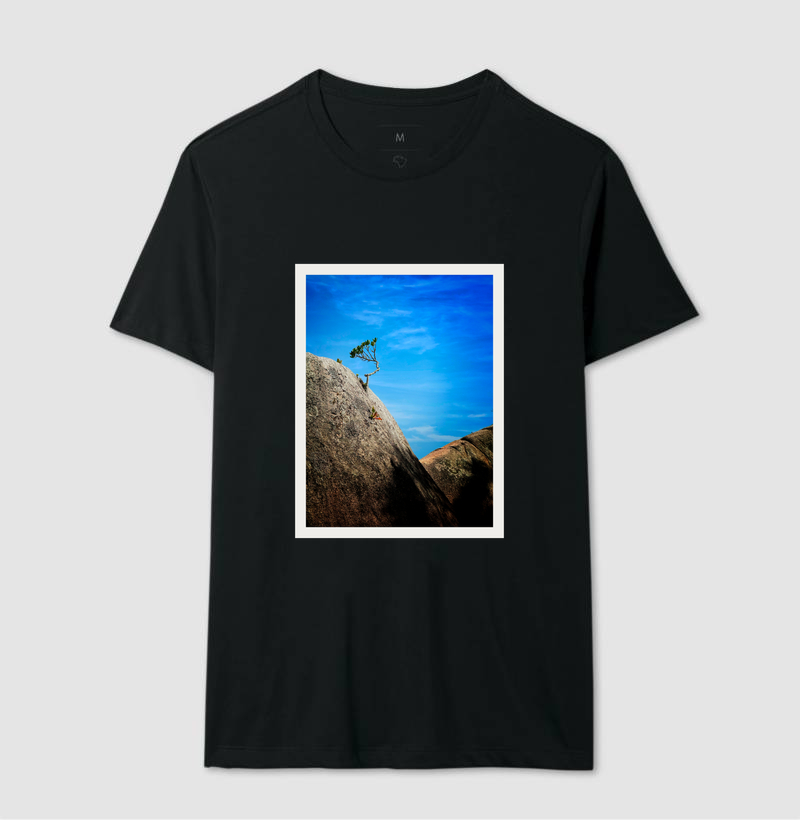 Camiseta preta com estampa de uma paisagem com rochas e céu azul.