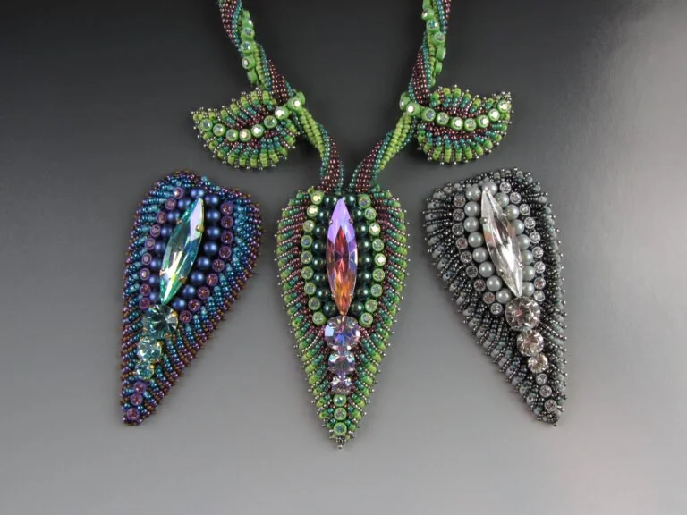 Colorful beaded necklace with leaf-shaped pendants and large central crystals.