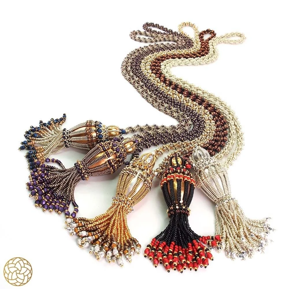 Colorful beaded necklace necklace with multiple tassels in various colors laid flat on a white surface.